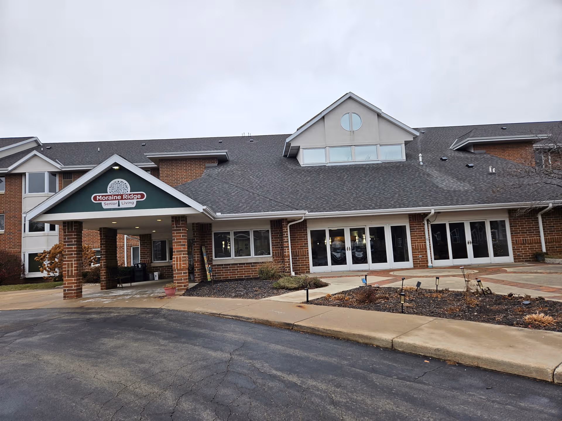 Moraine Ridge Senior Living building with brick exterior, covered entrance, and glass doors.