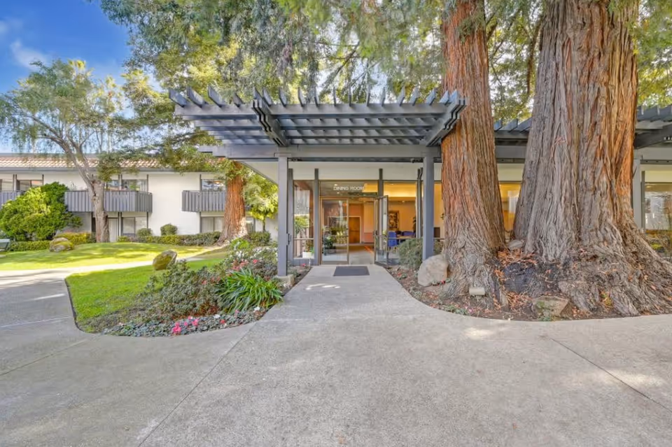 Exterior view of Easy Care Residential entrance with a covered walkway and tall trees.