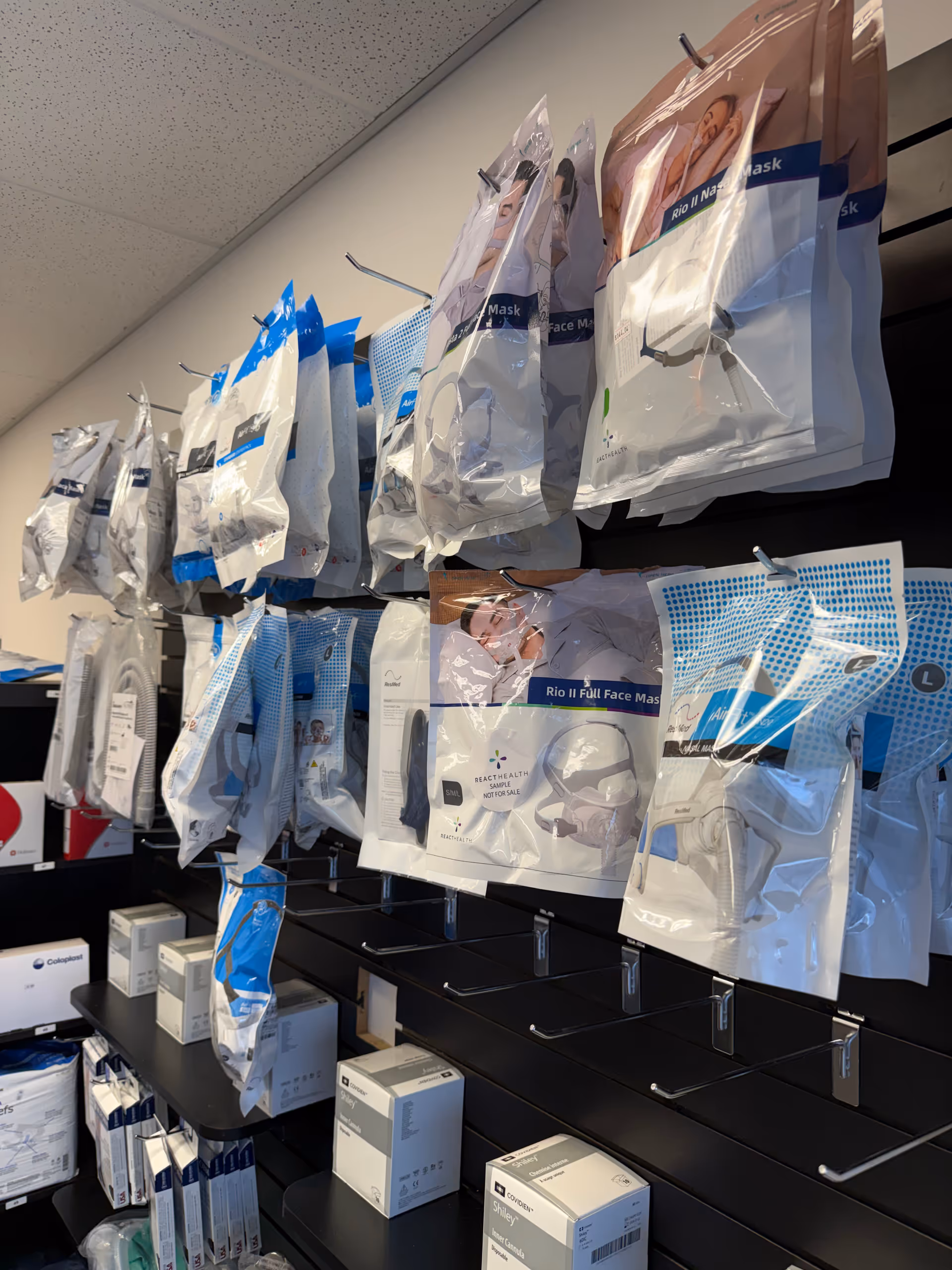 Rows of packaged face masks and medical supplies on wall shelving.