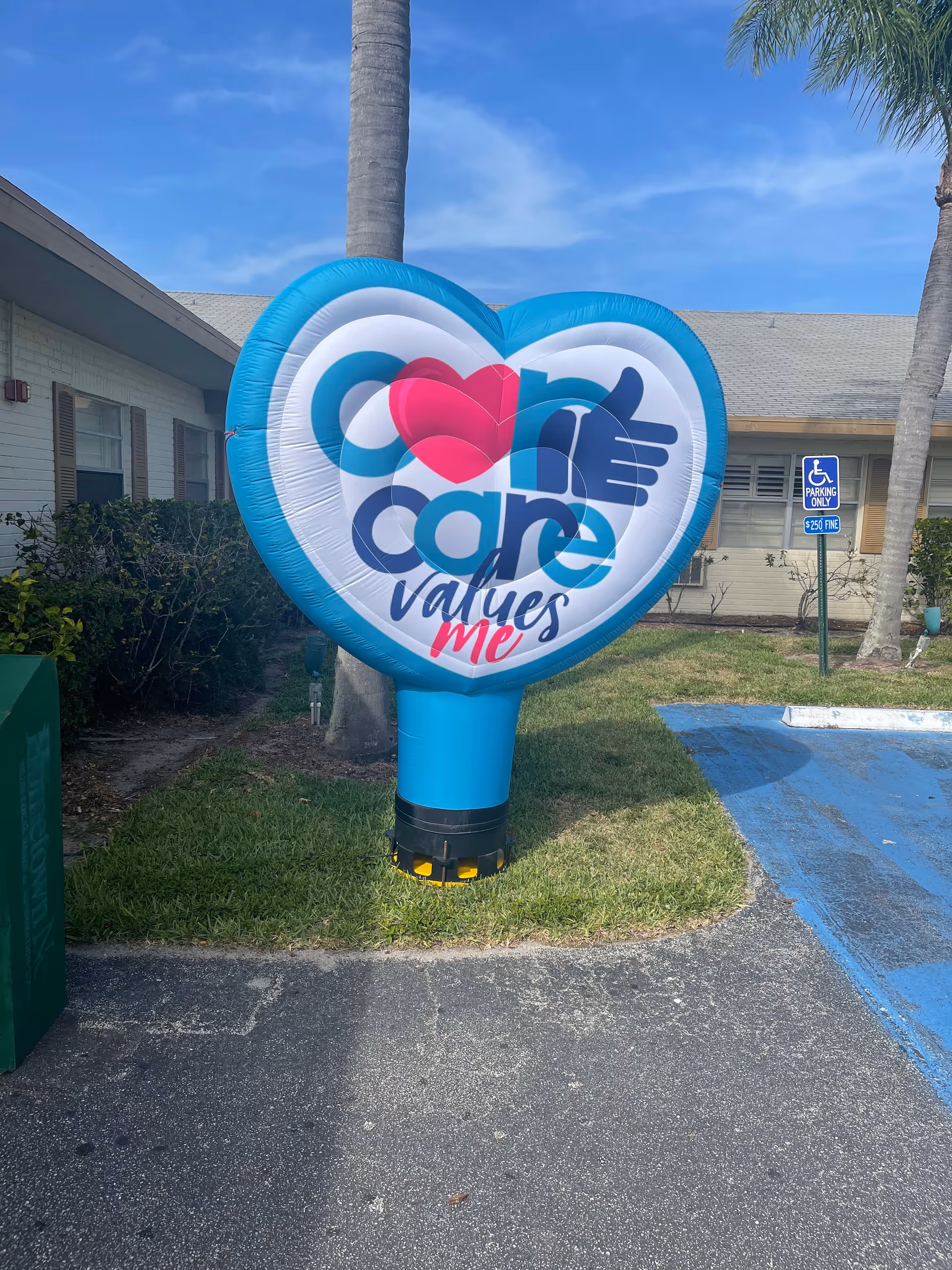 A large blue heart-shaped inflatable sign stands outside near the facility's front entrance.