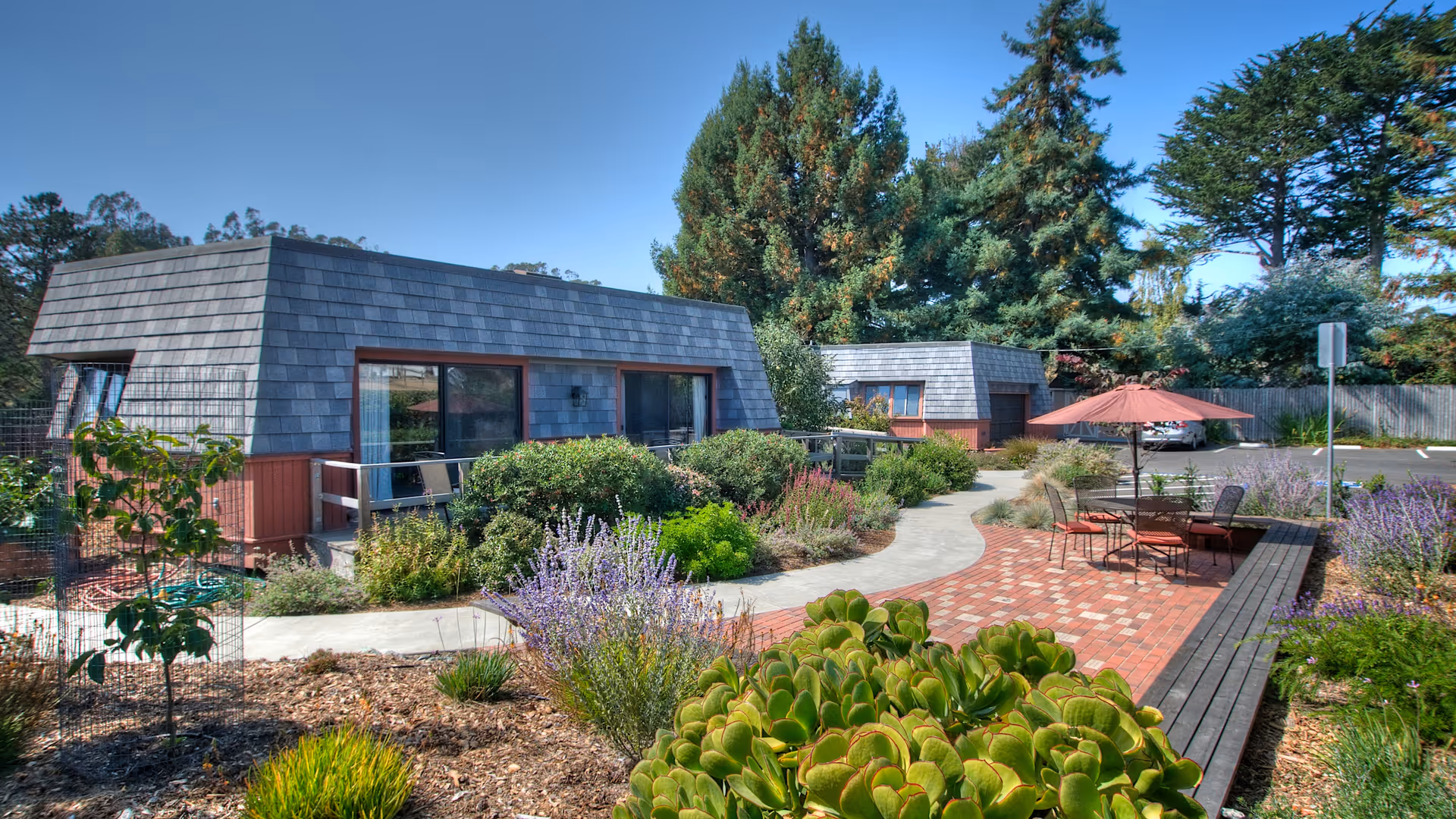Exterior view of West Marin Senior Services with garden and brick patio seating.
