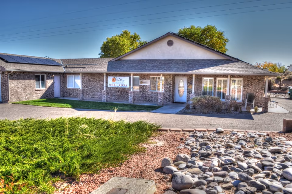 Front view of BeeHive Assisted Living home with brick exterior and rocky landscaping.