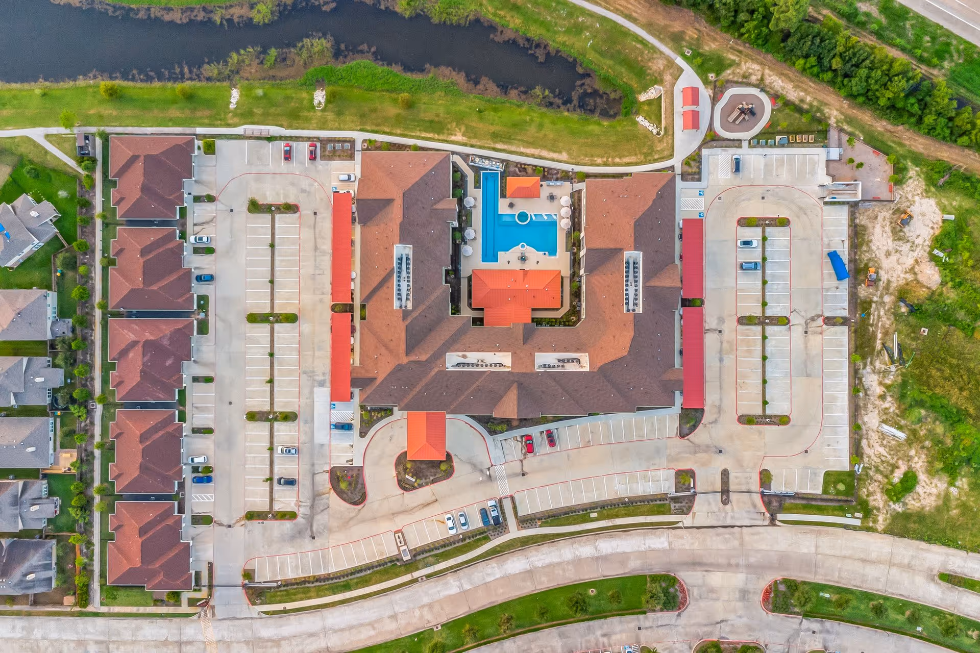 Aerial view of a senior living campus with pool and surrounding buildings