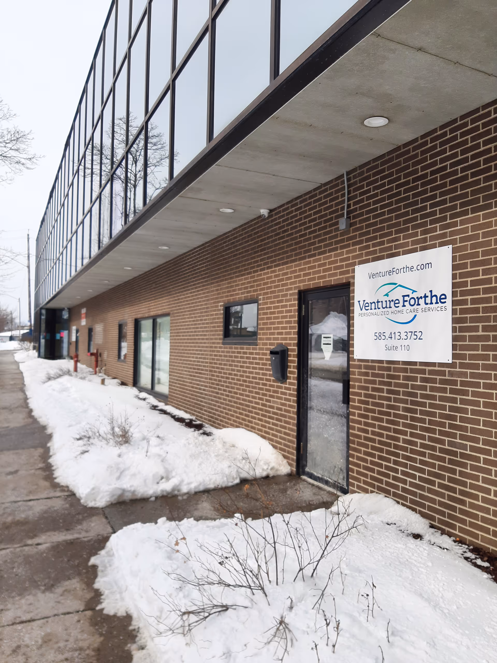 Exterior view of Venture Forthe Rochester Office and Training Center with brick wall and snow.