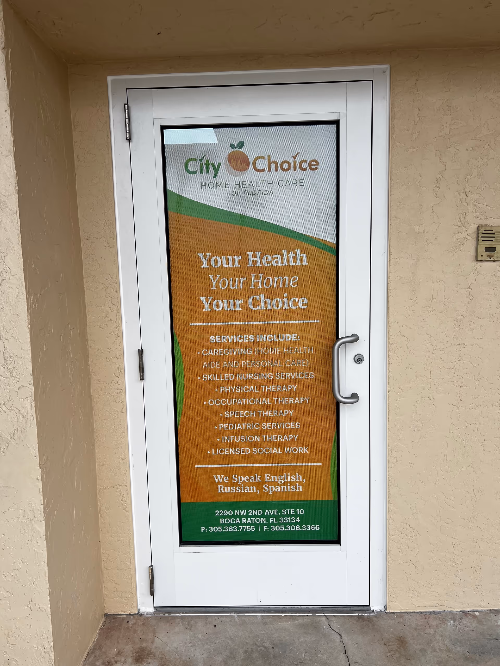 White-framed exterior door with a City Choice Home Health Care sign on the glass.