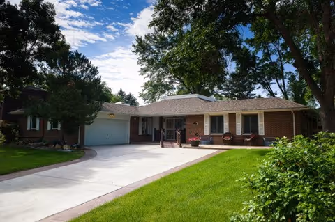 Single-story brick assisted living facility with a curved driveway and front yard.