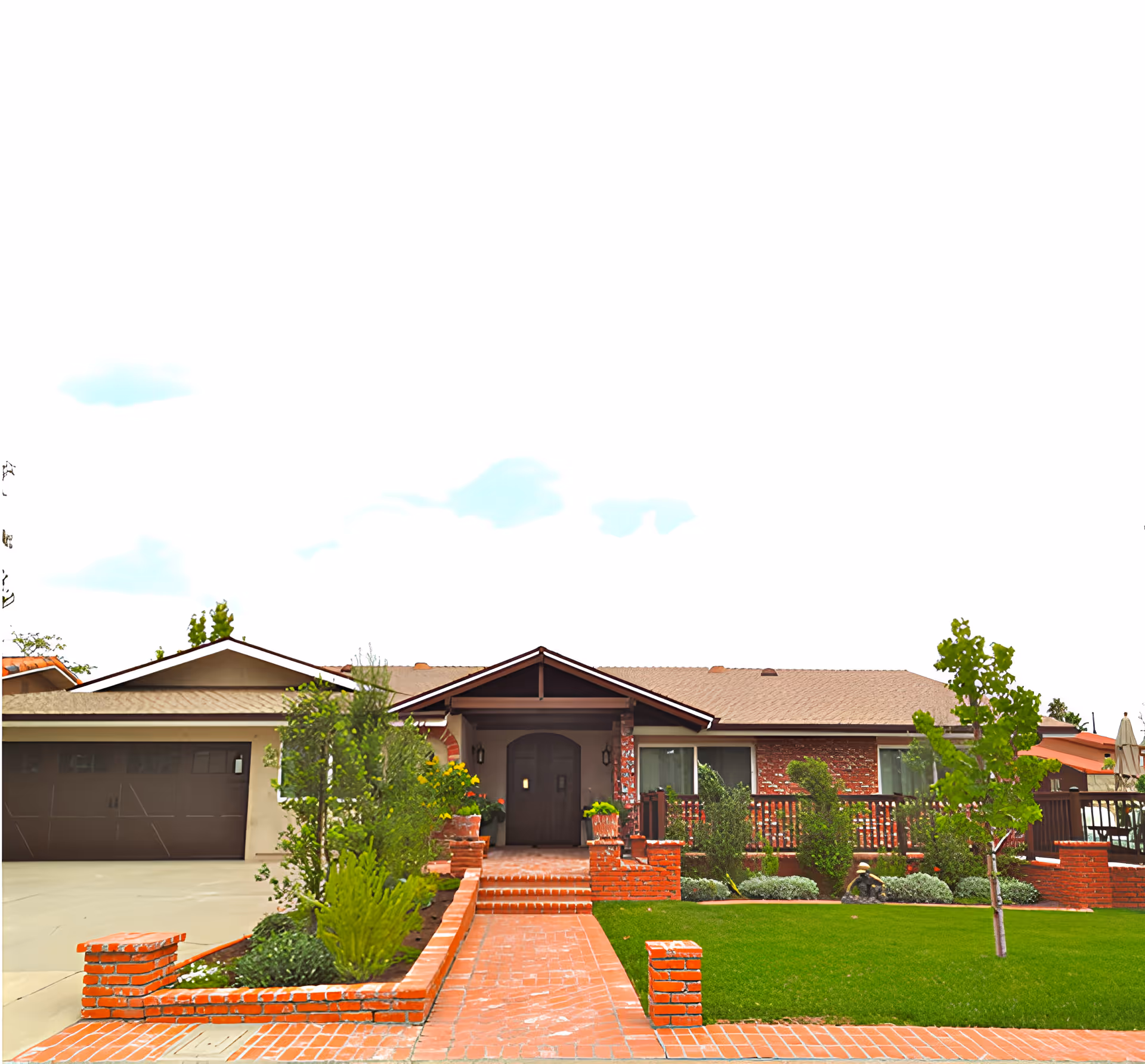 Front exterior view of a single-story residential building with a brick pathway leading to a covered entrance. The house features a brown garage door on the left, brick walls, and a well-maintained lawn with shrubs and small trees.
