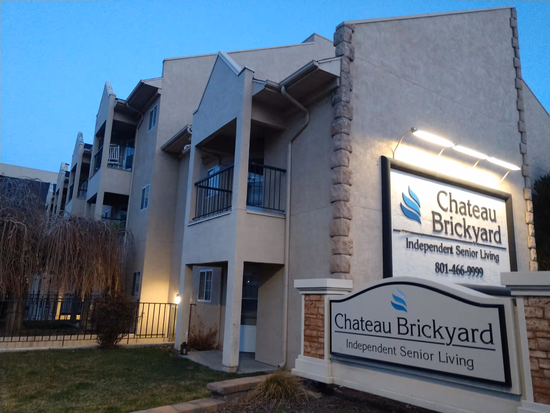 Exterior view of a beige senior living building with balconies and a Chateau Brickyard sign.