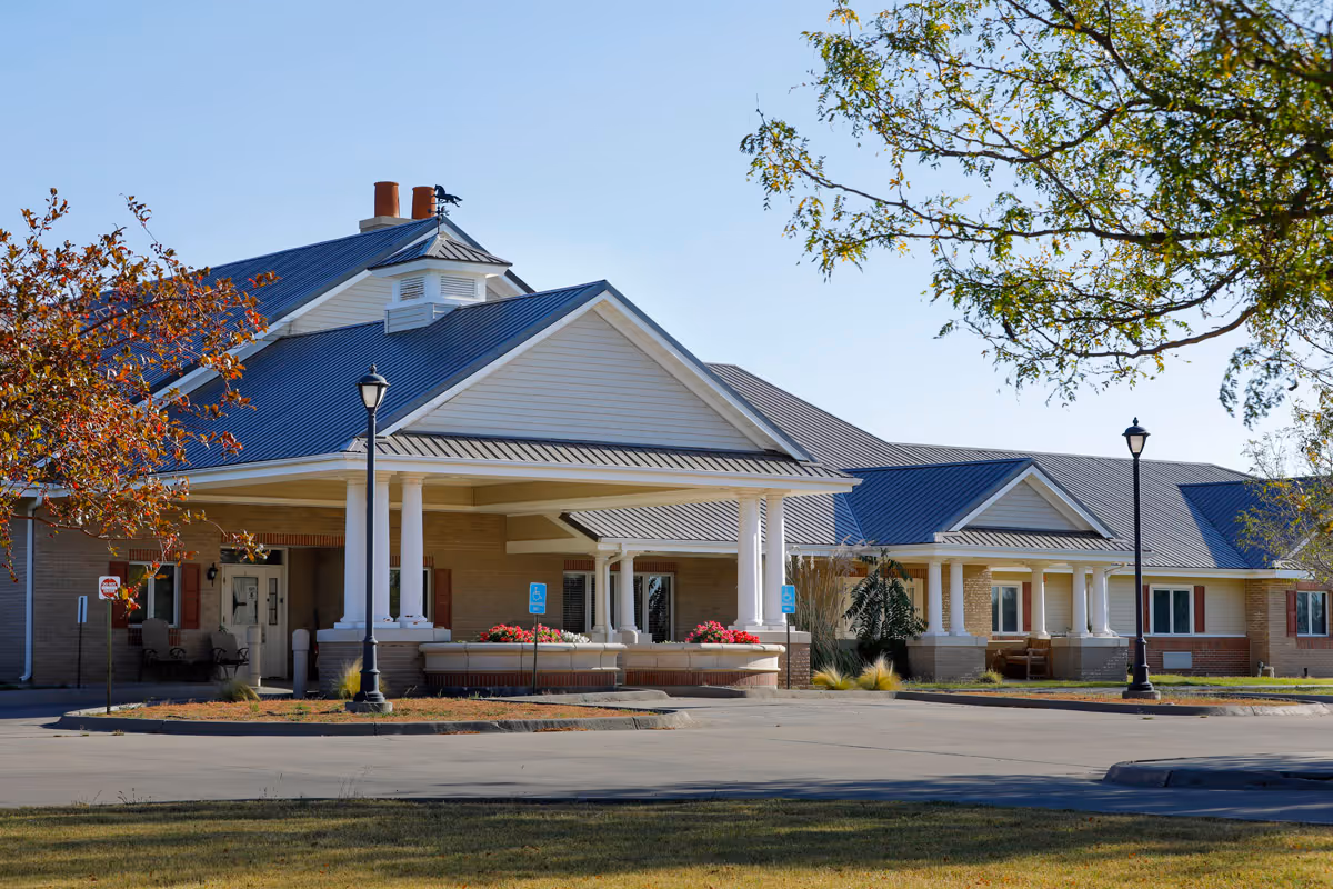 Single-story assisted living facility with a covered entrance, columns, and landscaped front.