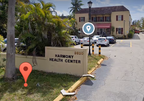 Exterior view of Harmony Health Center building, parking lot, and welcome sign.