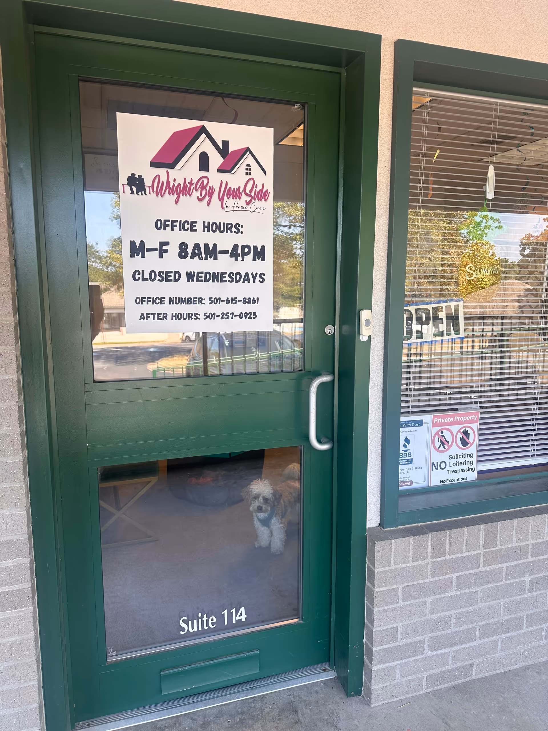 Green front door with Wright By Your Side sign and a small dog visible inside.