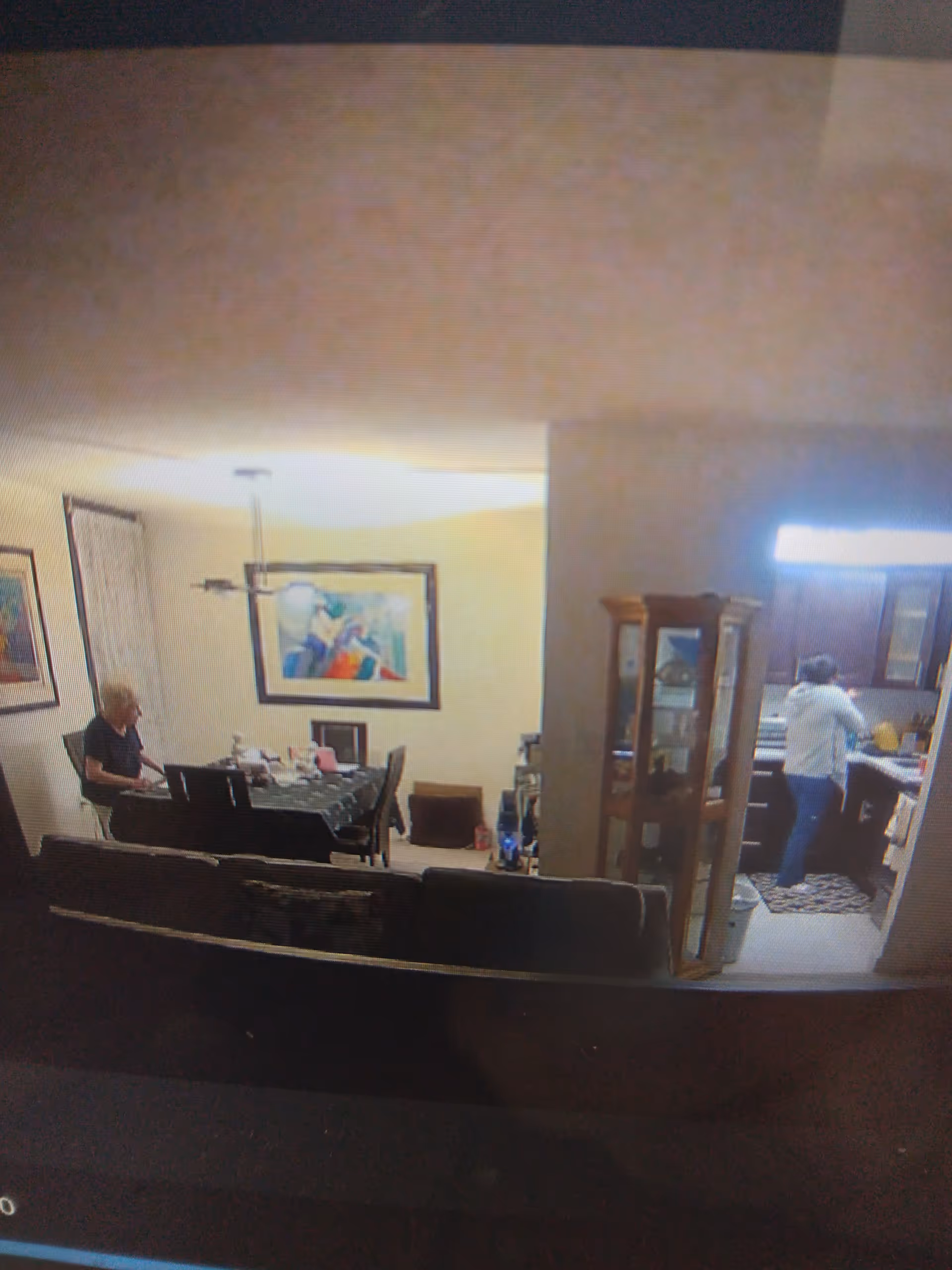 Interior living/dining area in a senior facility with a dining table, couch, and kitchen.