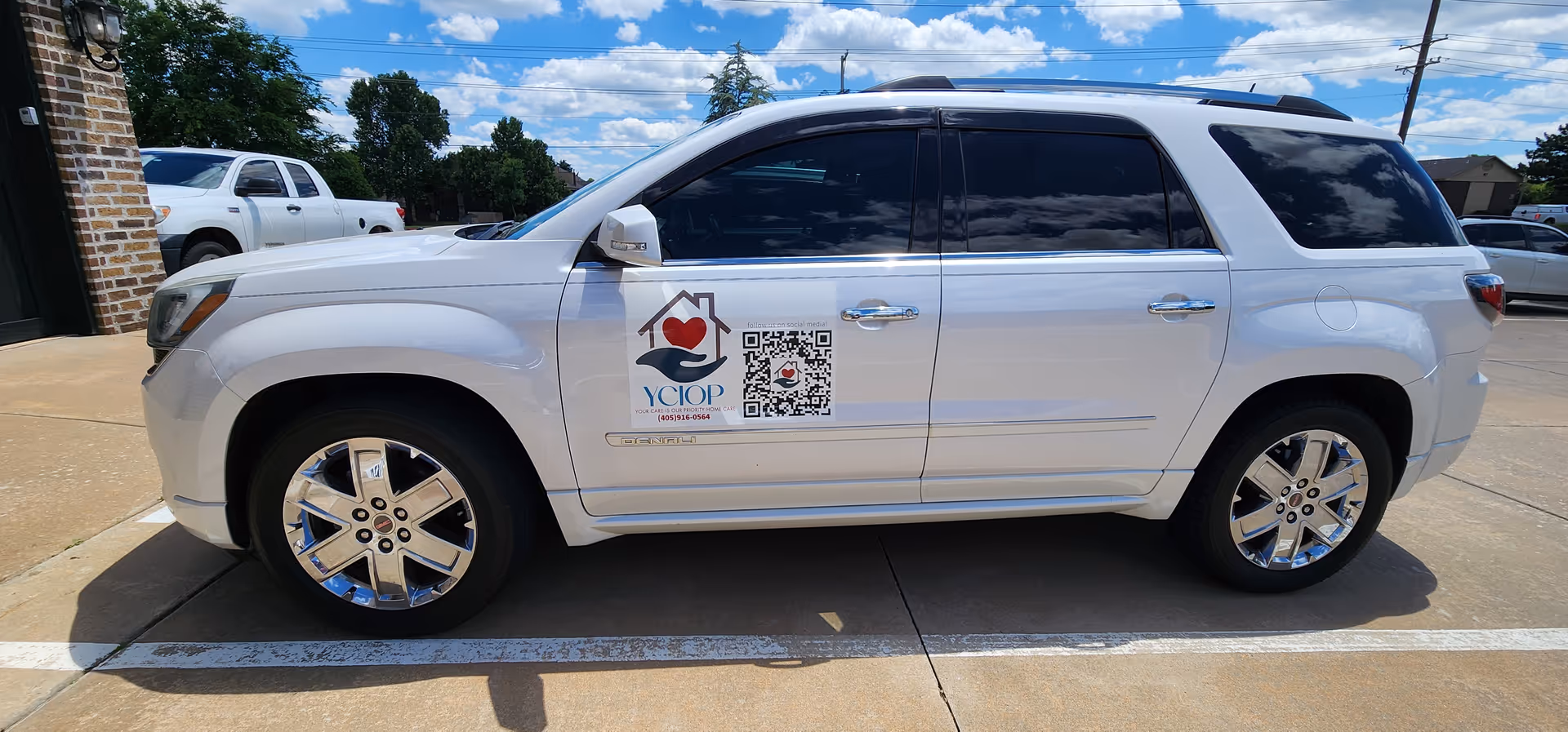 White SUV parked outside building featuring YCIOP Home Care logo on its door