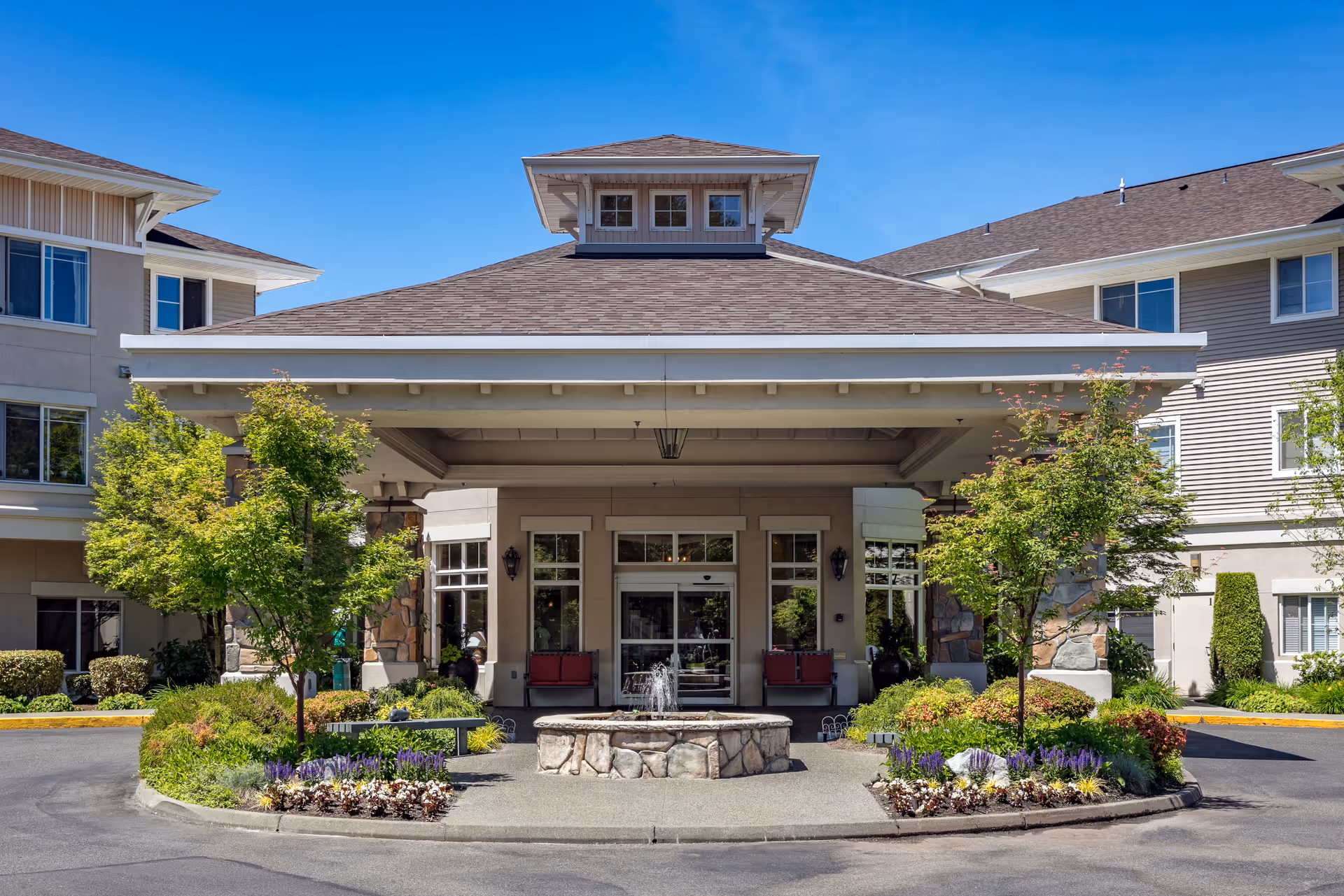 Front exterior of Fairwinds Brittany Park featuring a circular driveway, fountain, and manicured landscaping.