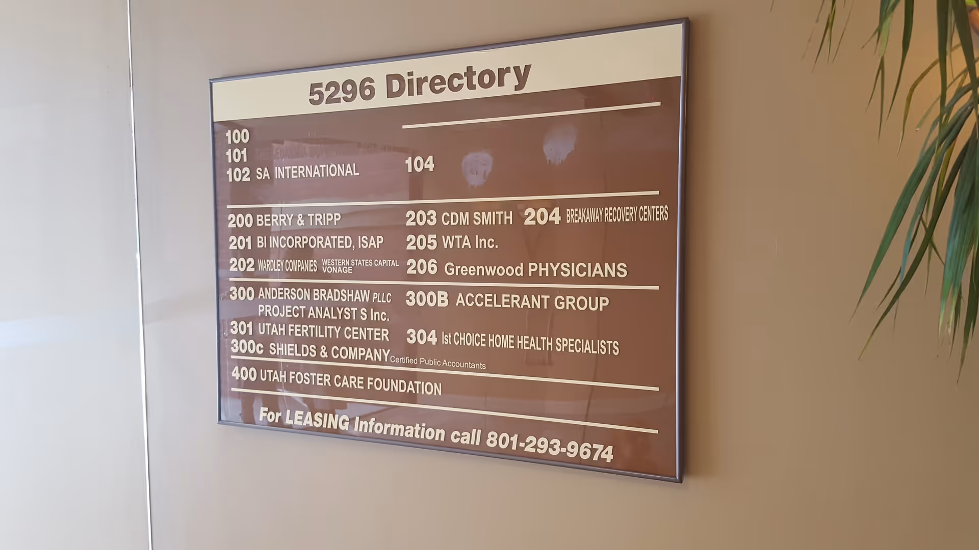 An interior wall directory plaque lists suite numbers and business names.