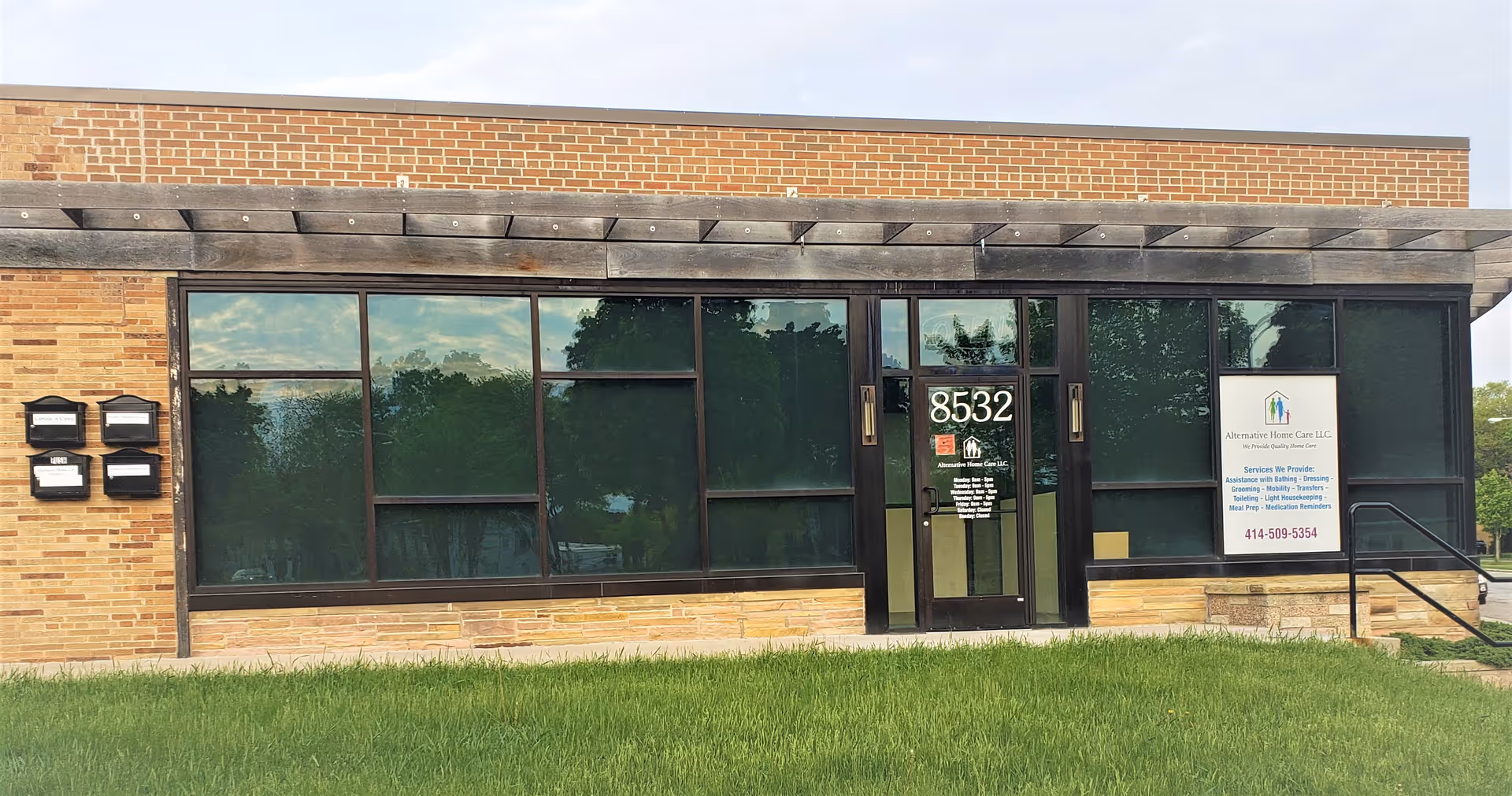 Brick storefront with large windows and a glass door labeled 8532.