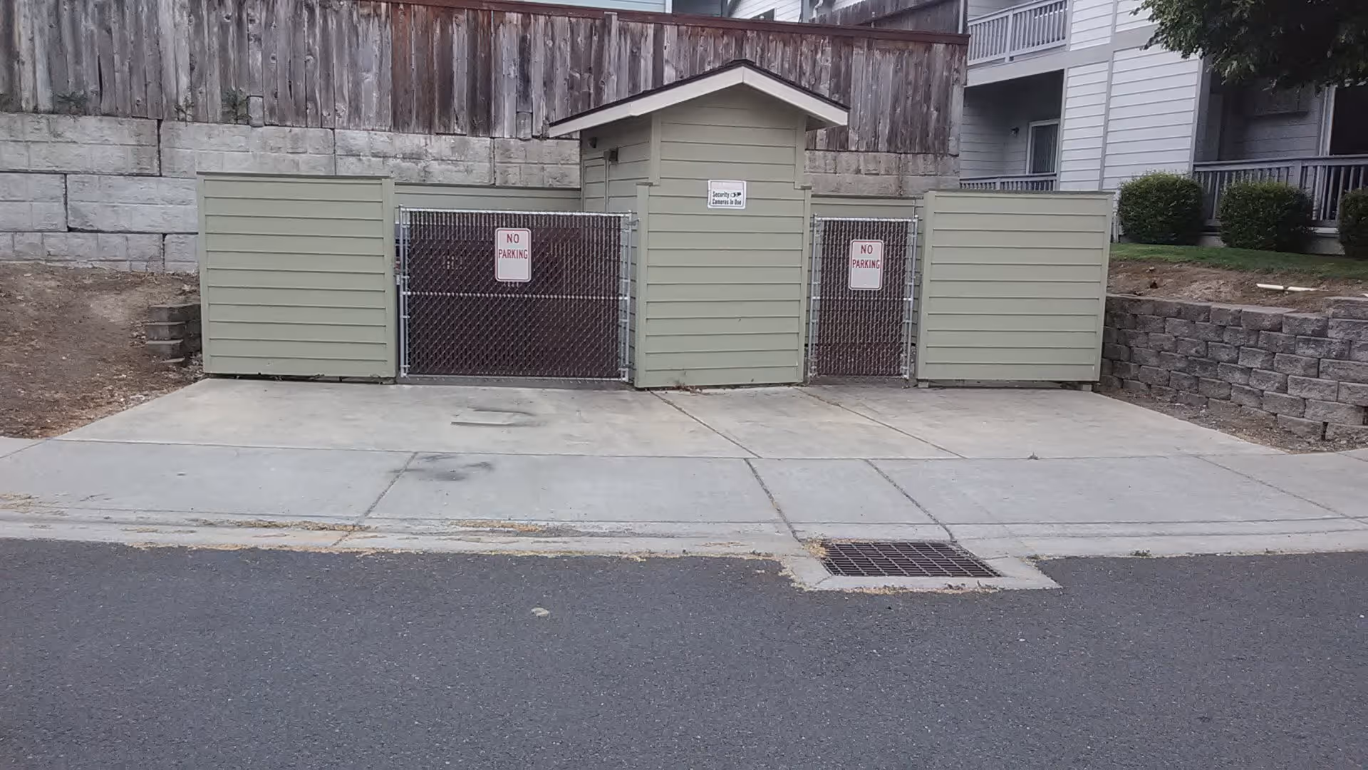Back area of Cedars facility with three storage sheds and chain-link gates.