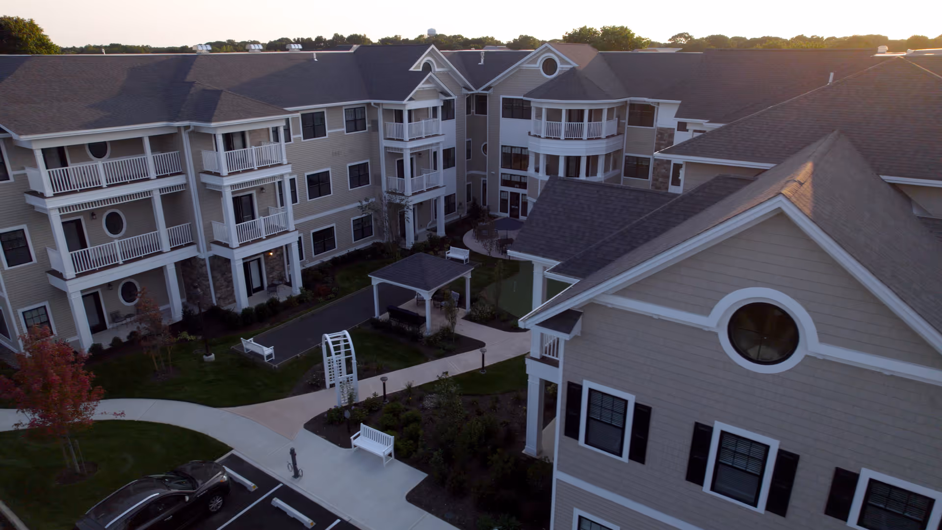 Brightview Port Jefferson exterior showing a multi-building senior living campus with balconies and a central courtyard.
