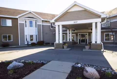 Exterior view of St Francis Terrace entrance featuring a covered porte-cochere and potted planters.
