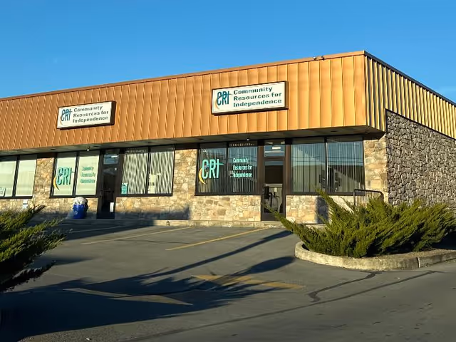 Exterior view of a brick-and-stone building with sign reading Community Resources for Independence.