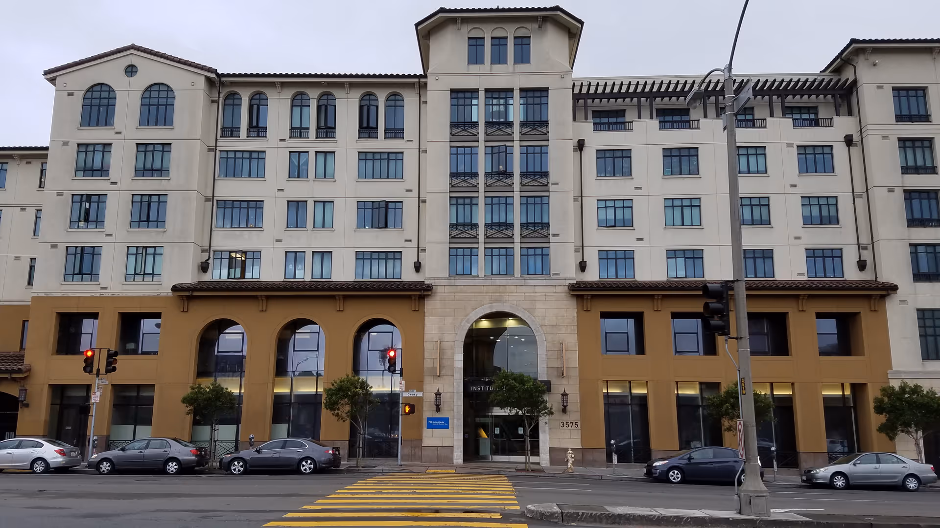Multi-story Institute on Aging San Francisco building facade with arched windows along a city street.