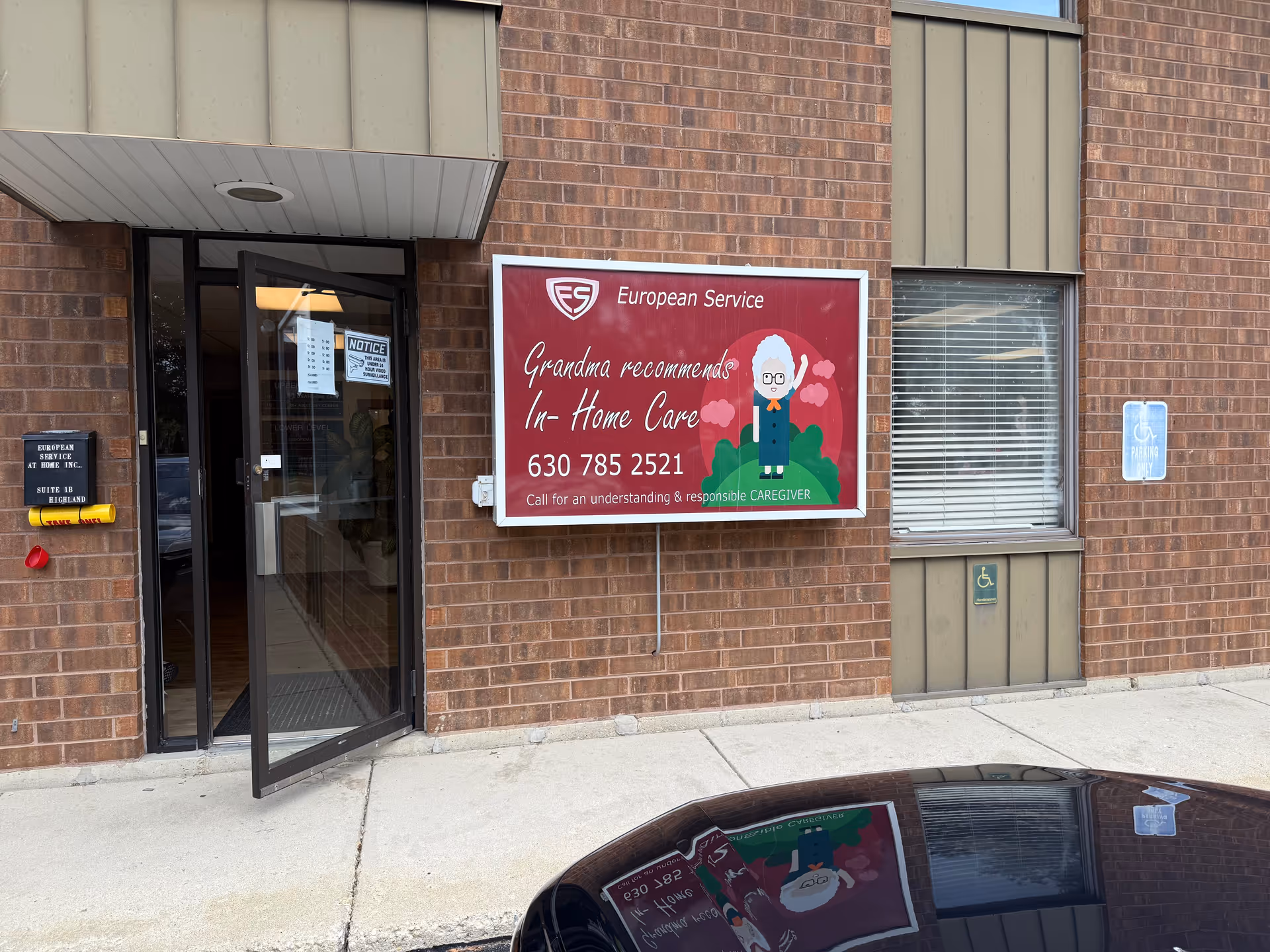 Brick building exterior with an open glass entrance and European Service In-Home Care sign.