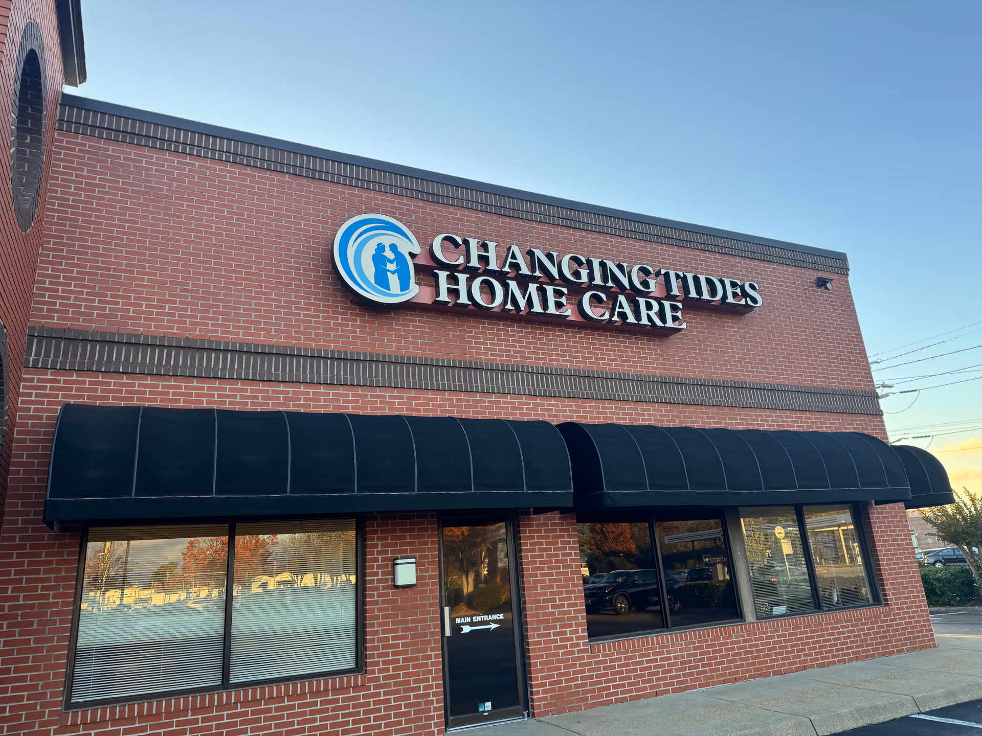 Brick storefront with Changing Tides Home Care sign and black awning.