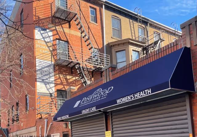 Brick building with blue awning advertising Pinewood Family Care and Women's Health.