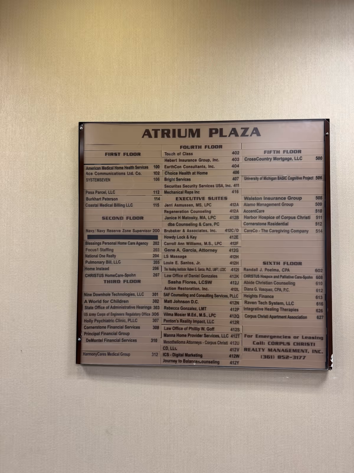 Interior wall features an Atrium Plaza directory board listing offices.