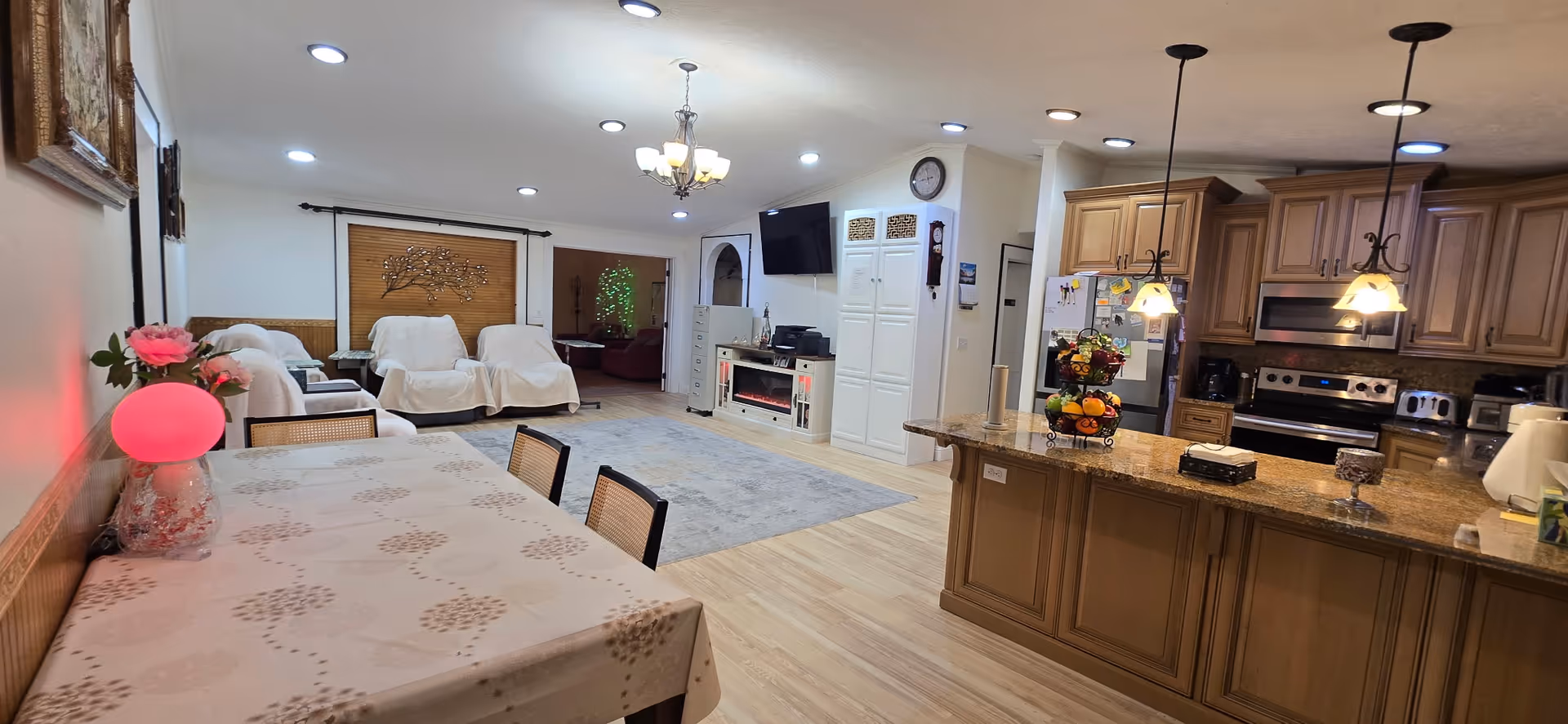 Open-concept living area with kitchen, dining table, and seating in a senior home.