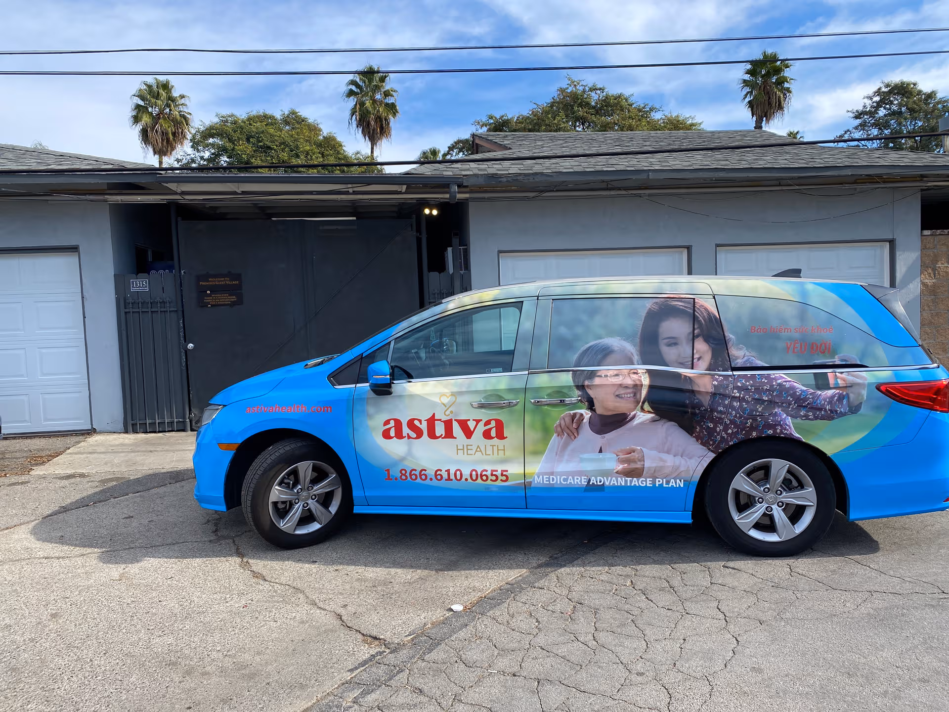 Blue promotional van with elderly care ads parked in front of a gray building.