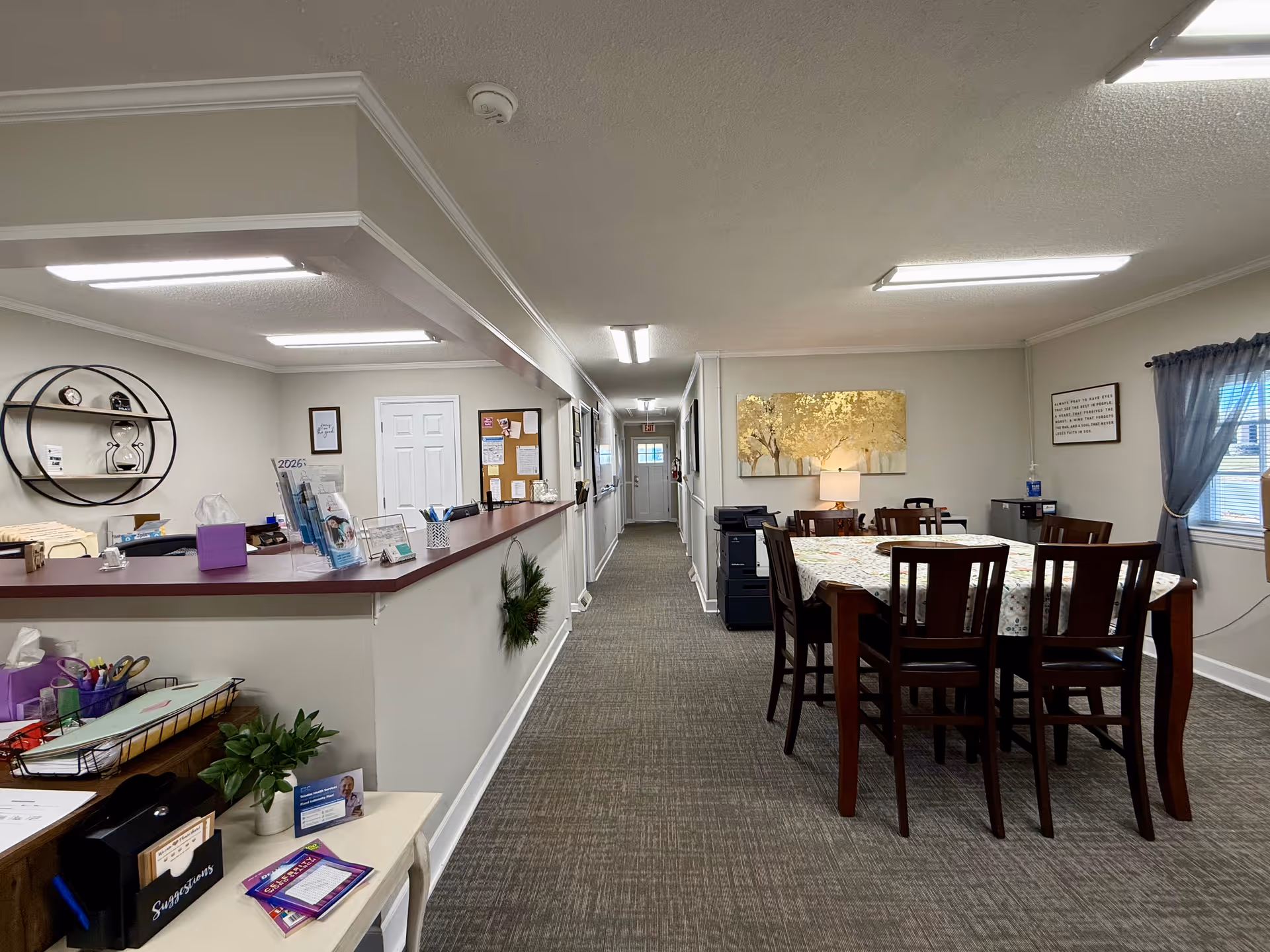 Interior of a senior living facility featuring a reception desk and dining area.