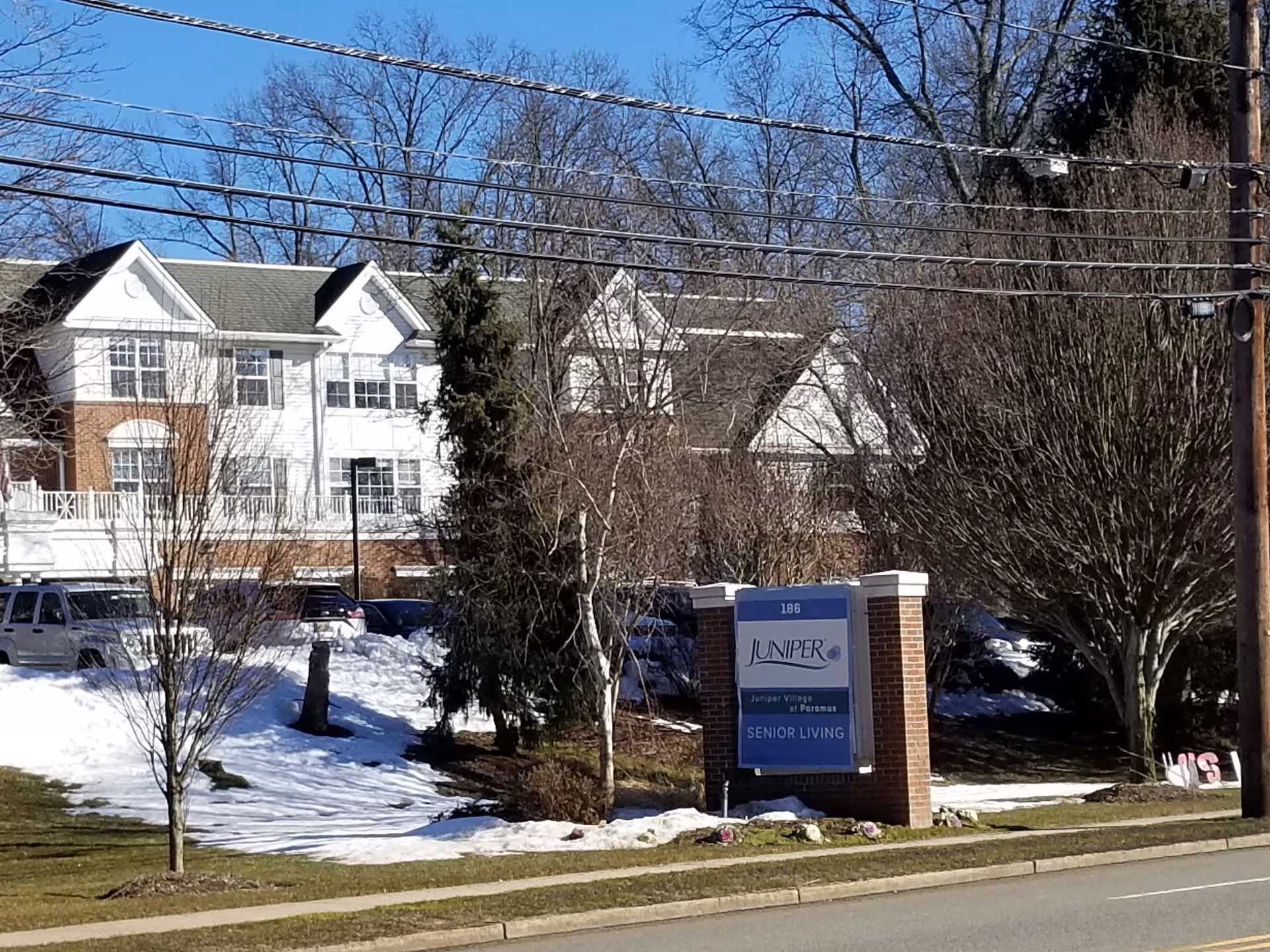 Senior living facility exterior with a Juniper Village sign and snow-covered landscaping.
