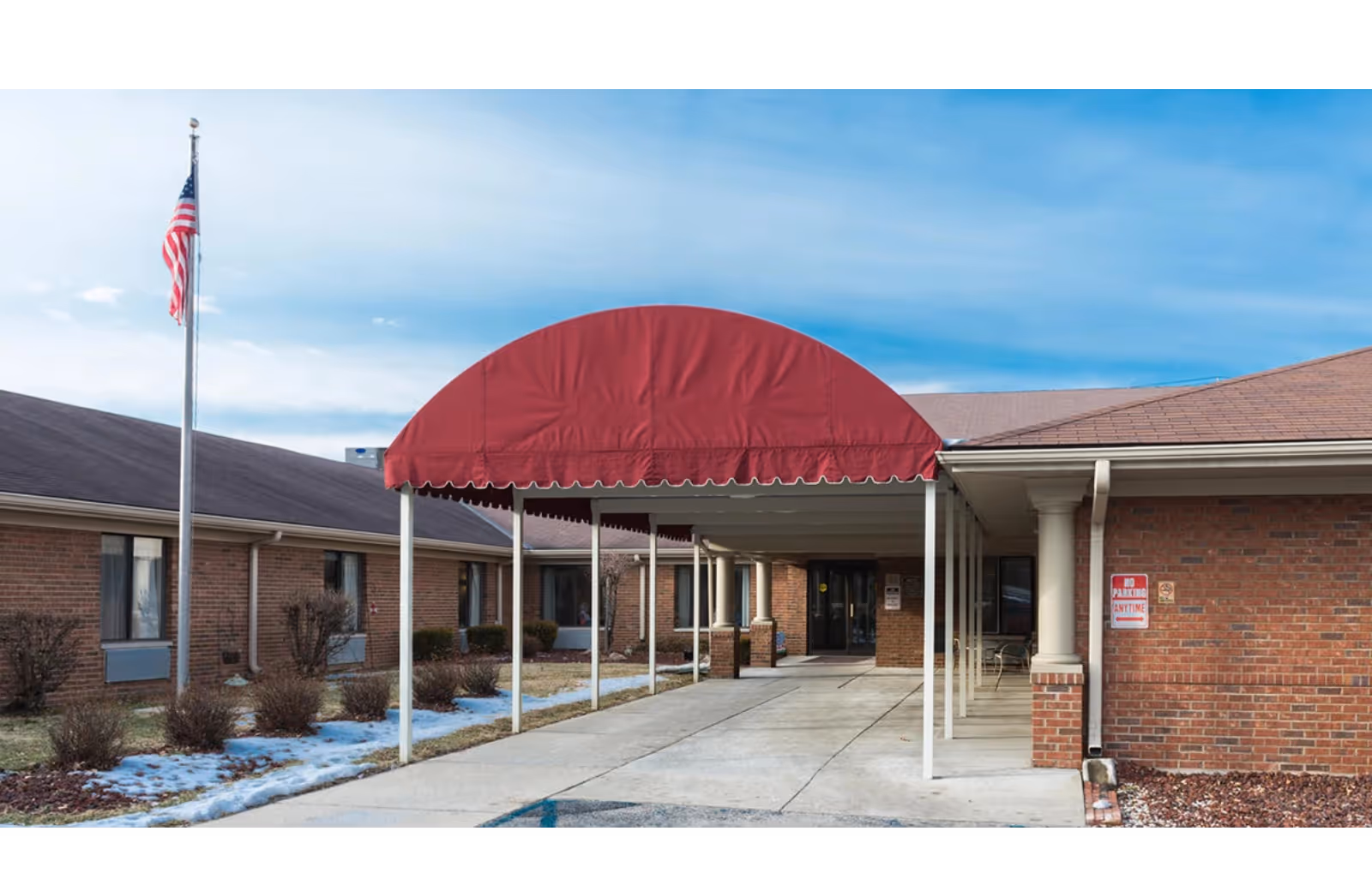 Exterior view of Legacy Riverview featuring brick buildings and a red entrance canopy.