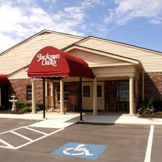 Entrance of Brookdale Jackson Oaks with red canopy and accessible parking.