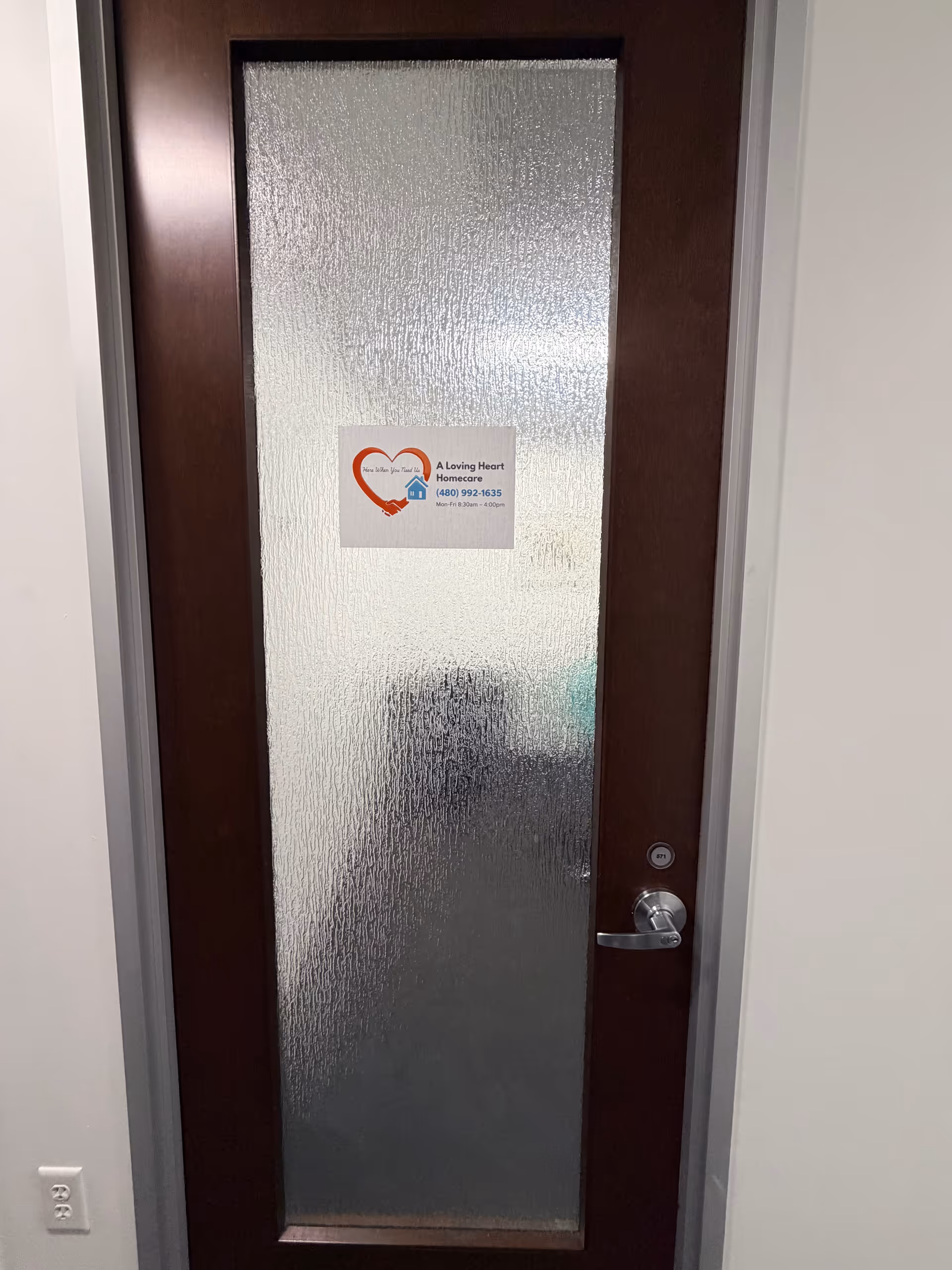 Wood-framed frosted glass interior door with a sticker for A Loving Heart Homecare LLC.