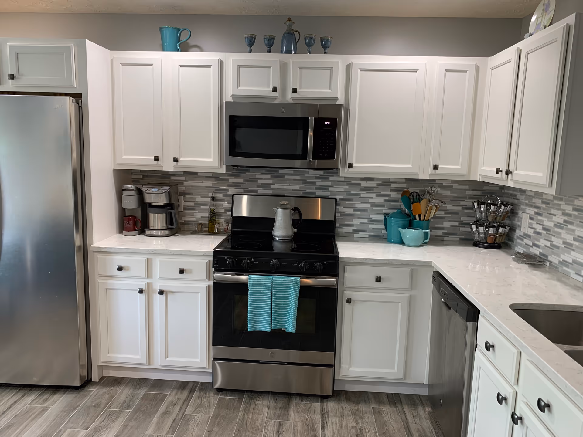 White kitchen with stainless steel appliances, tiled backsplash, and turquoise accents at Mercy Health StoneBridge.