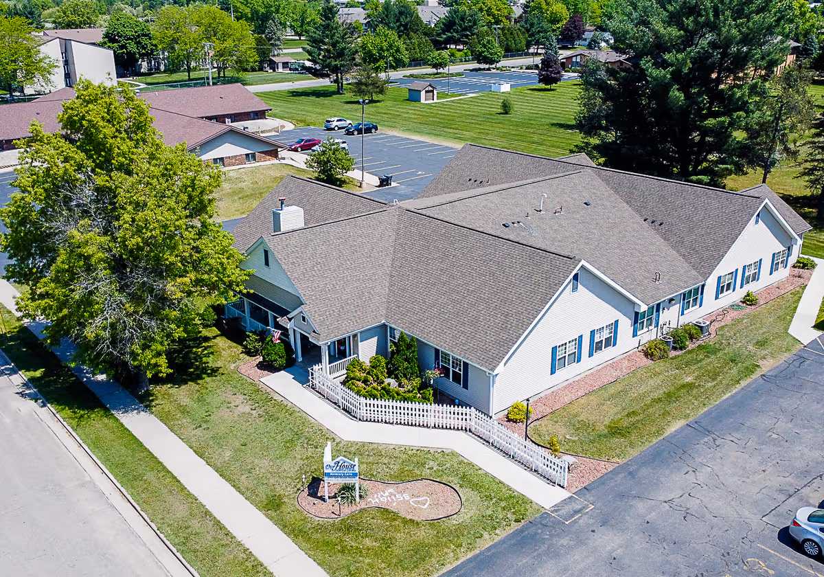 Aerial view of a single-story senior living building with white siding and a ramped entrance.
