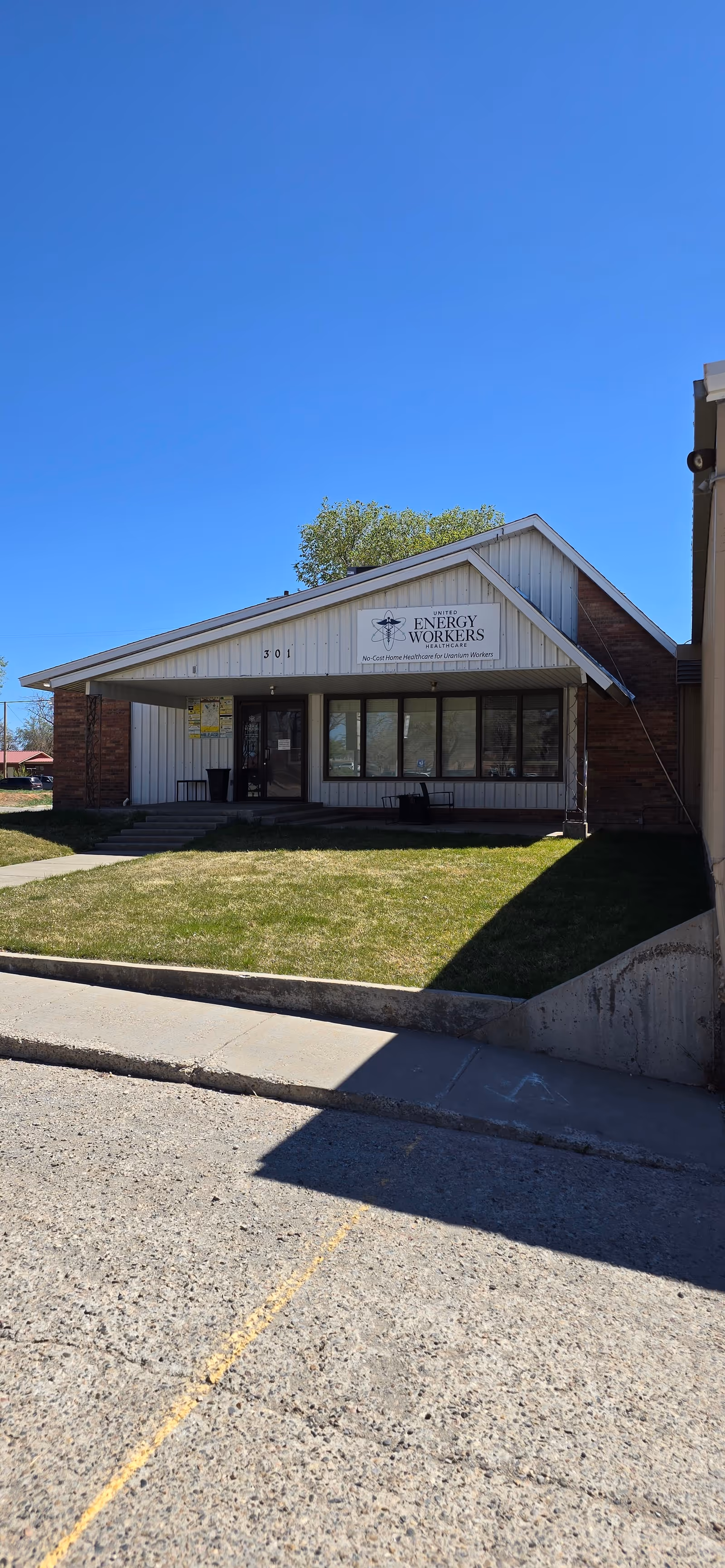 Exterior front view of a single-story building with a peaked roof and sign.