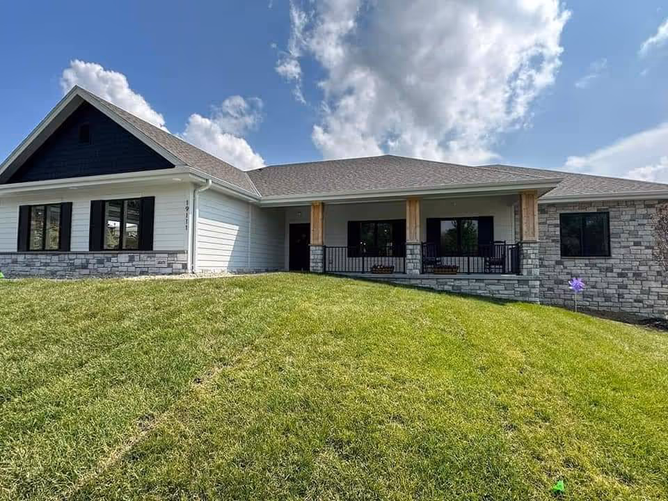 A single-story senior living building with stone accents and a grassy front yard.