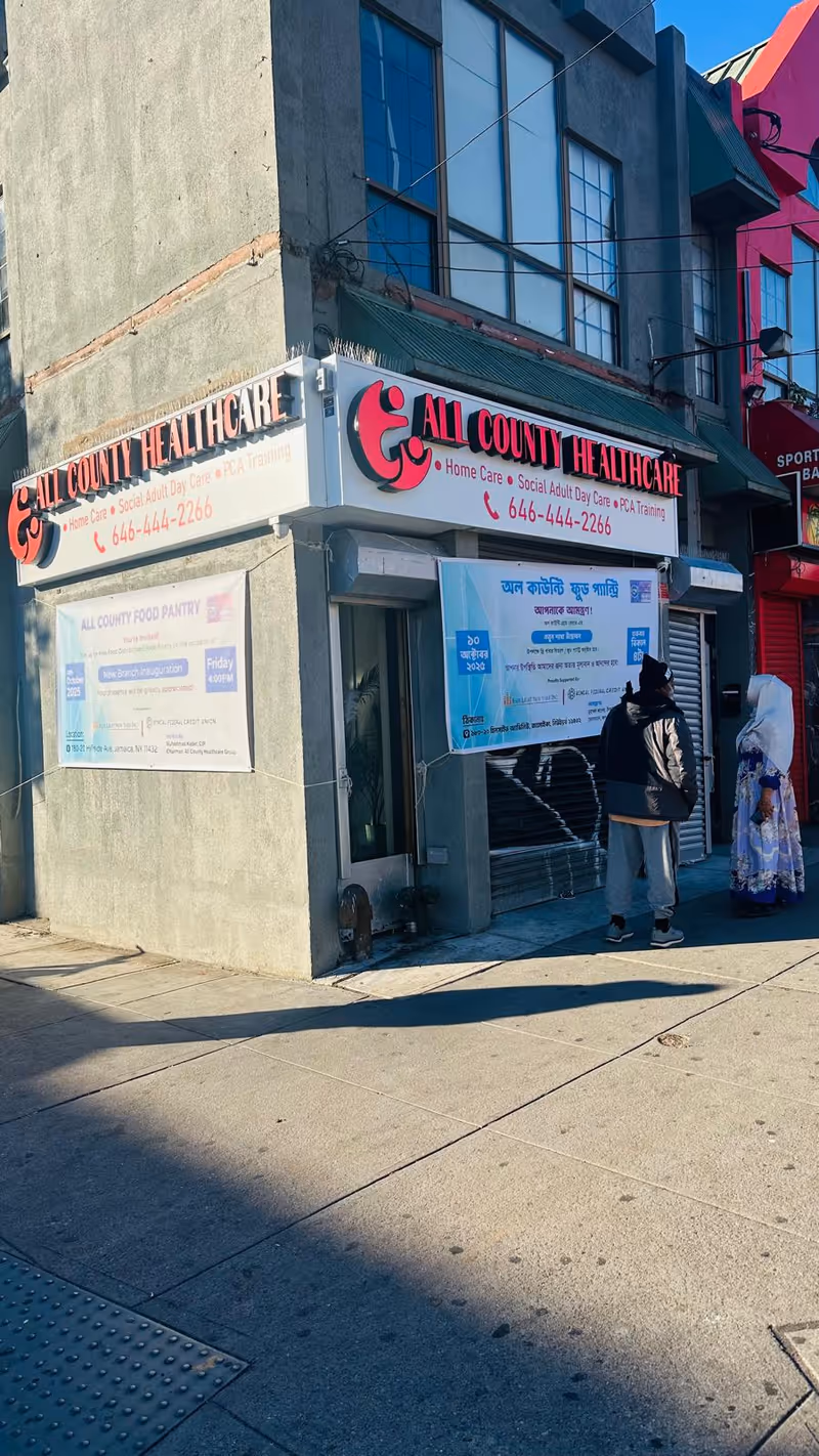 Storefront of All County Healthcare with red sign; two people stand outside.
