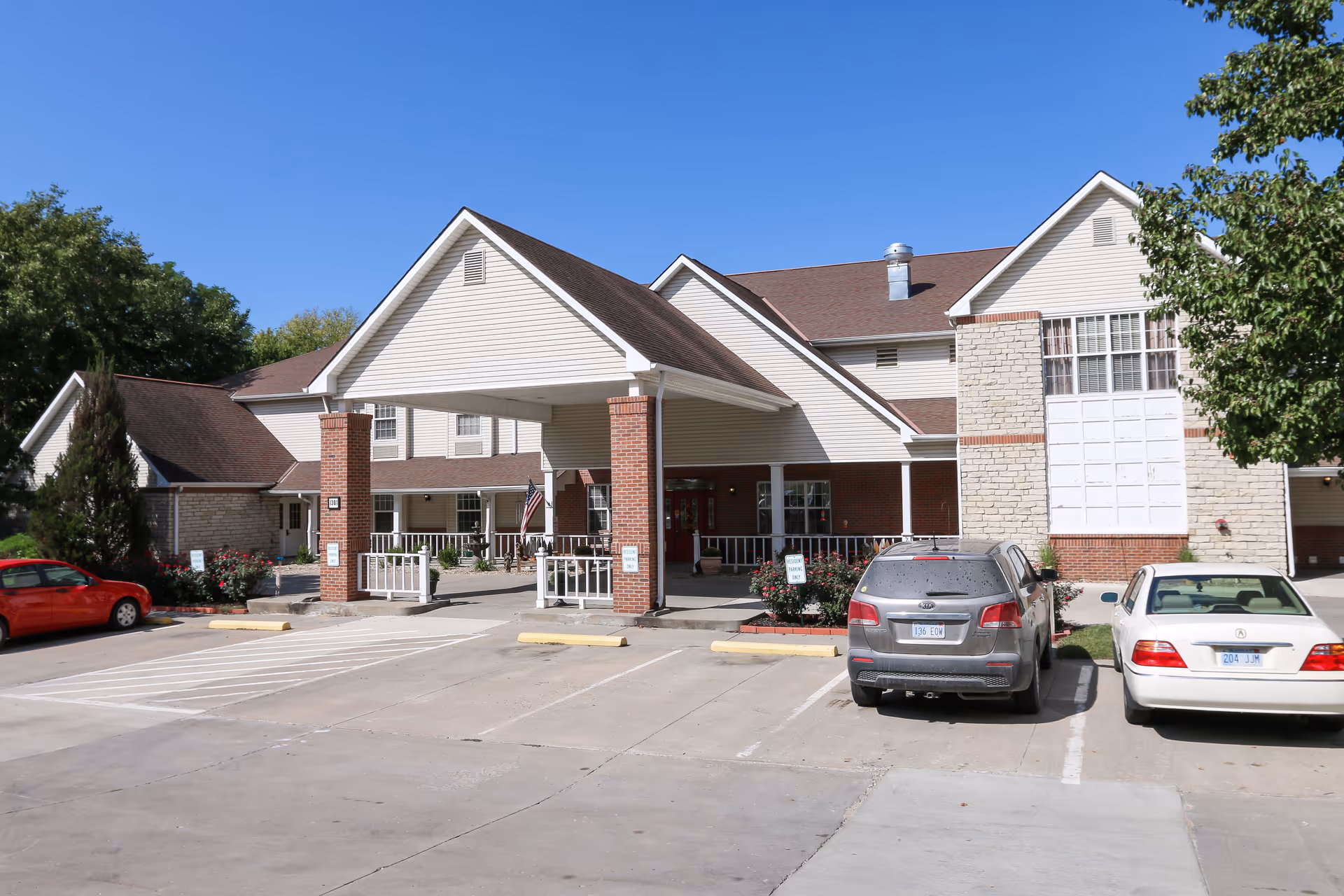 Exterior view of Vintage Park at Atchison featuring the front entrance and parked cars.