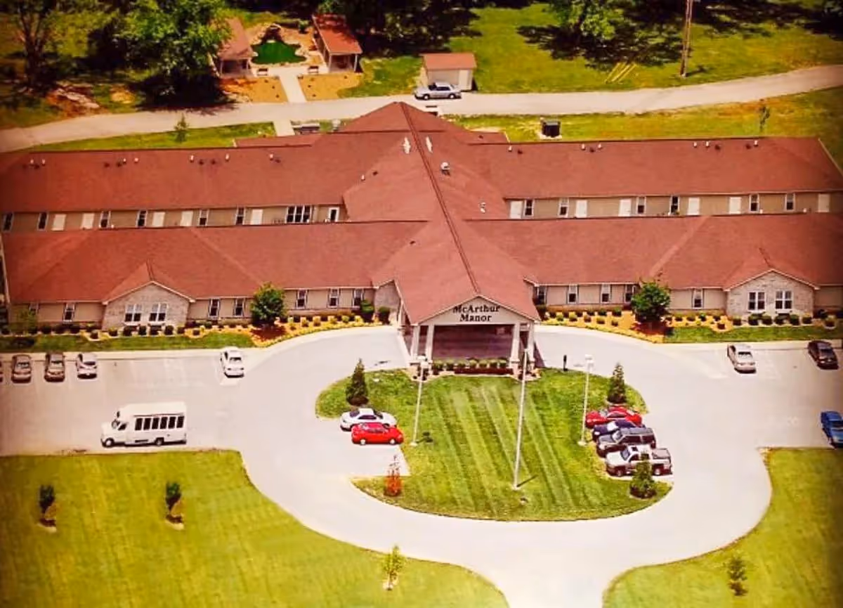 Aerial view of McArthur Manor Assisted Living building, with circular driveway and parking.