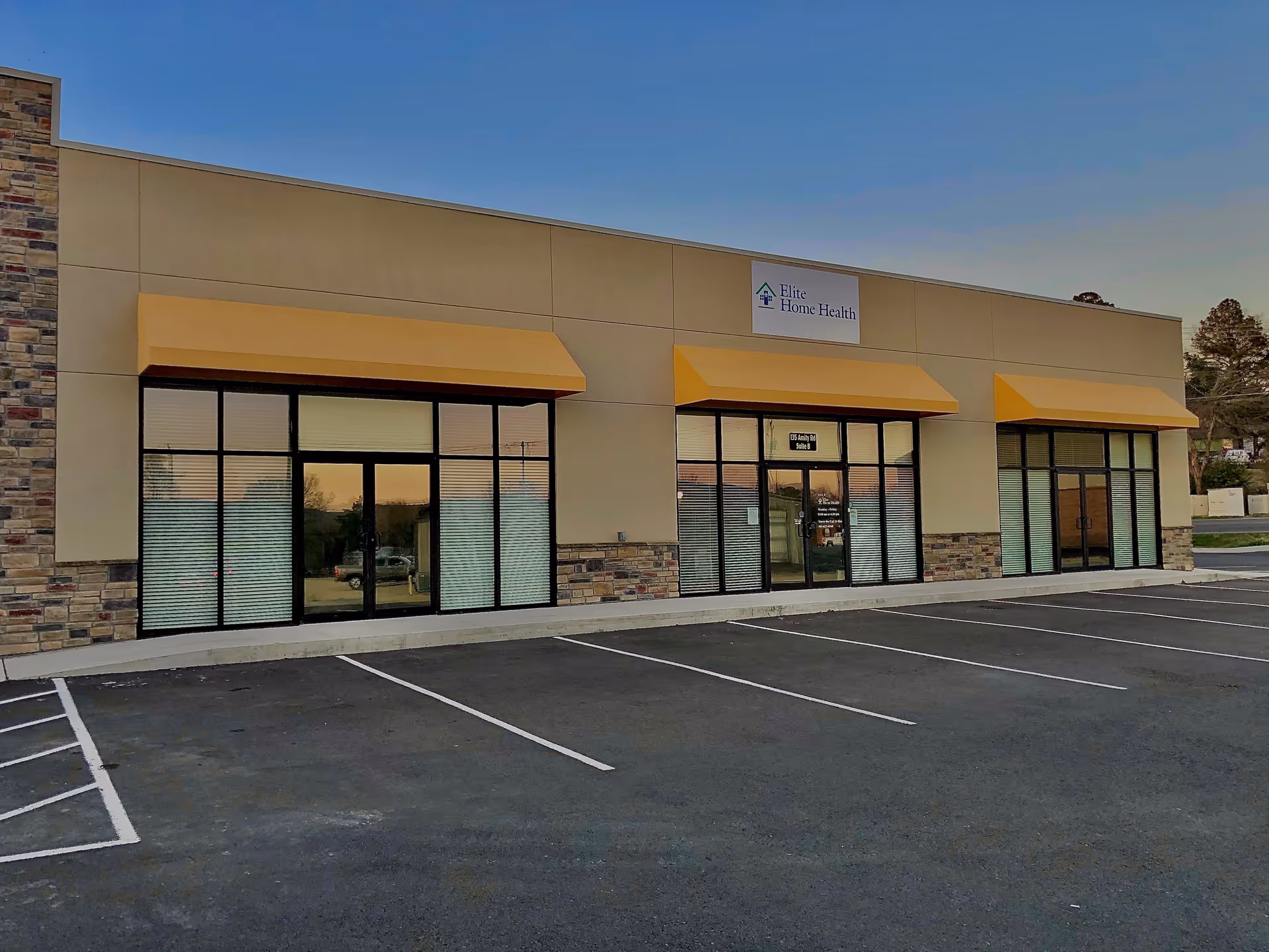 Exterior of a single-story medical office for Elite Home Health of Hot Springs with orange awnings
