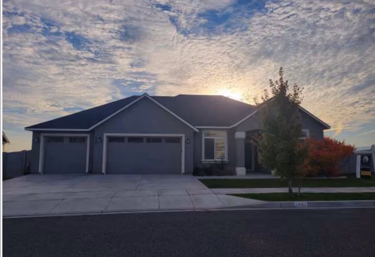 Front view of a single-story residential facility with three garage doors.