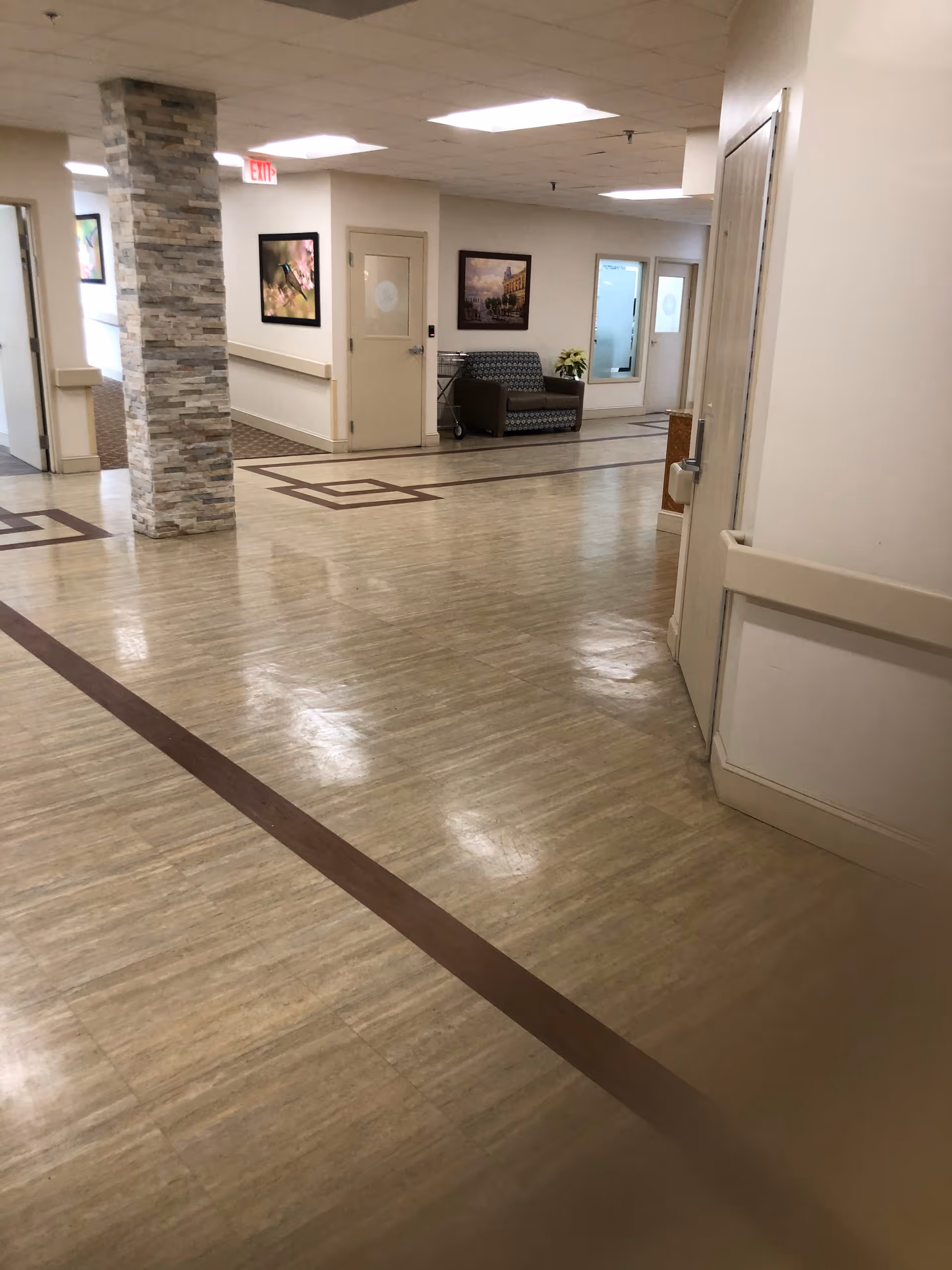 Brush Hill Care Center interior hallway with seating and framed artwork.