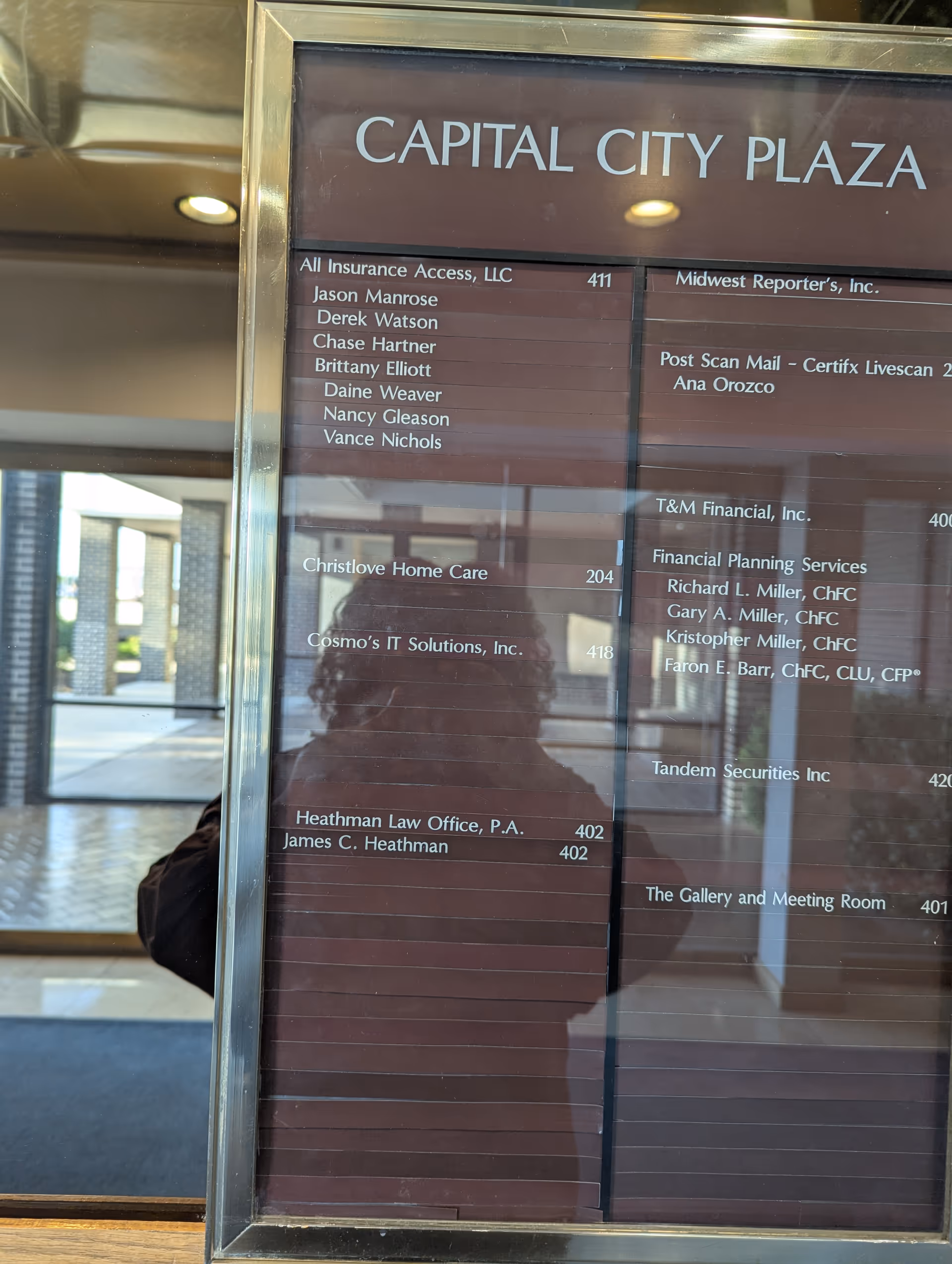 A lobby directory board at Capital City Plaza lists Christlove Home Care, with a photographer's reflection.