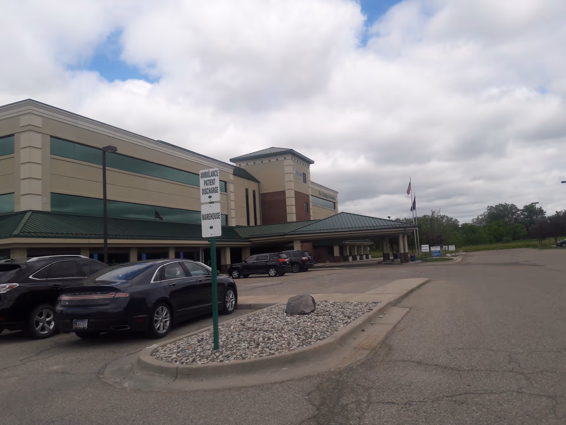 Exterior view of a McLaren Health Management Group facility with parking and entrance canopy.