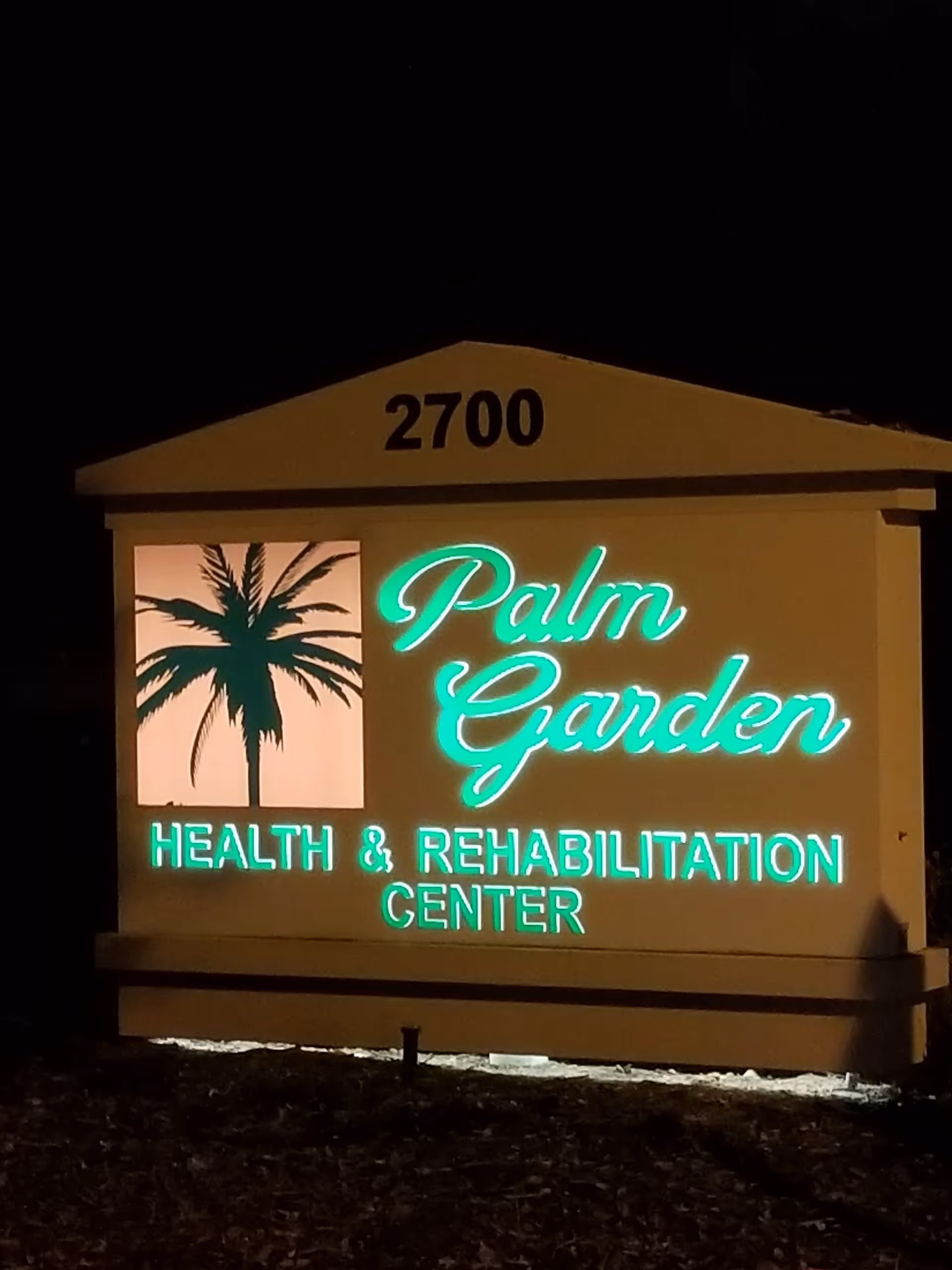 Nighttime exterior sign for Palm Garden Health & Rehabilitation Center at 2700