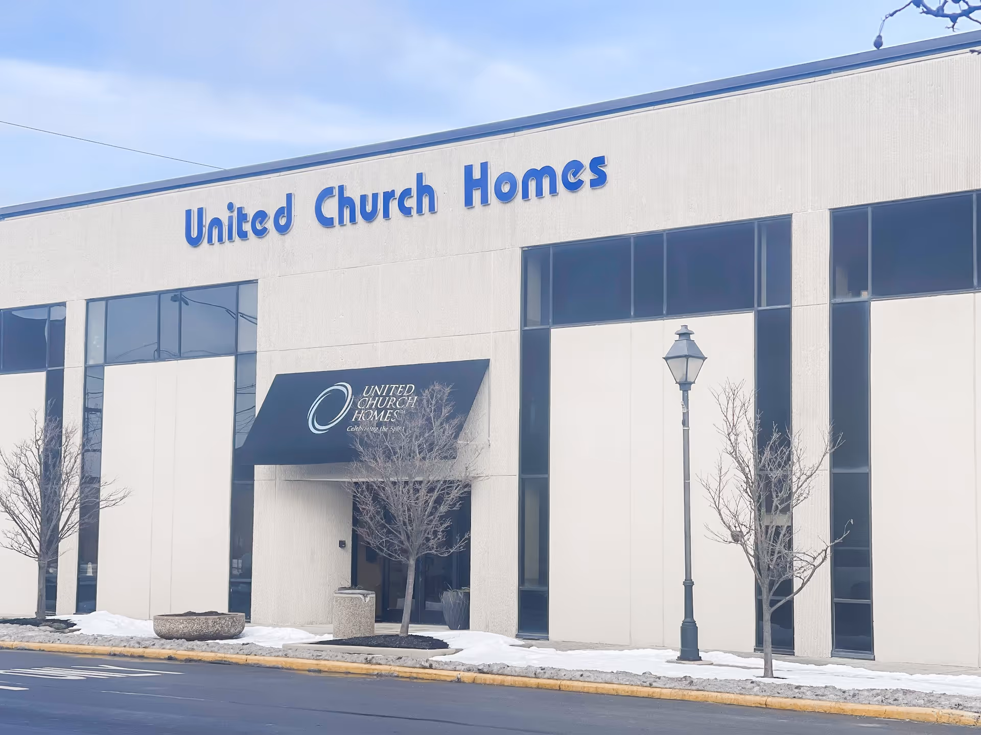 Front view of United Church Homes building with signage and leafless trees.